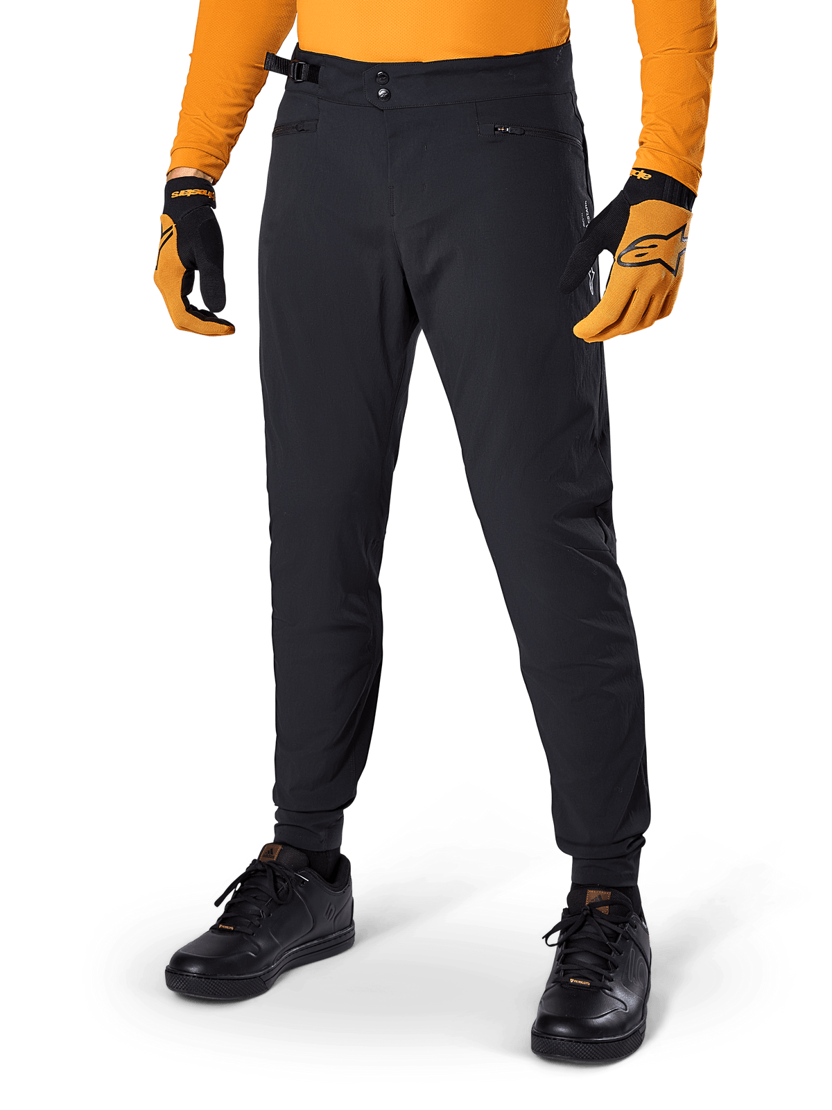 Alpinestars A-Dura Pants, pantaloni da mountain bike, nero, regolatori laterali in vita e tasche con zip, indossati con maglia e guanti arancioni, vestibilità regular sportiva per la guida MTB