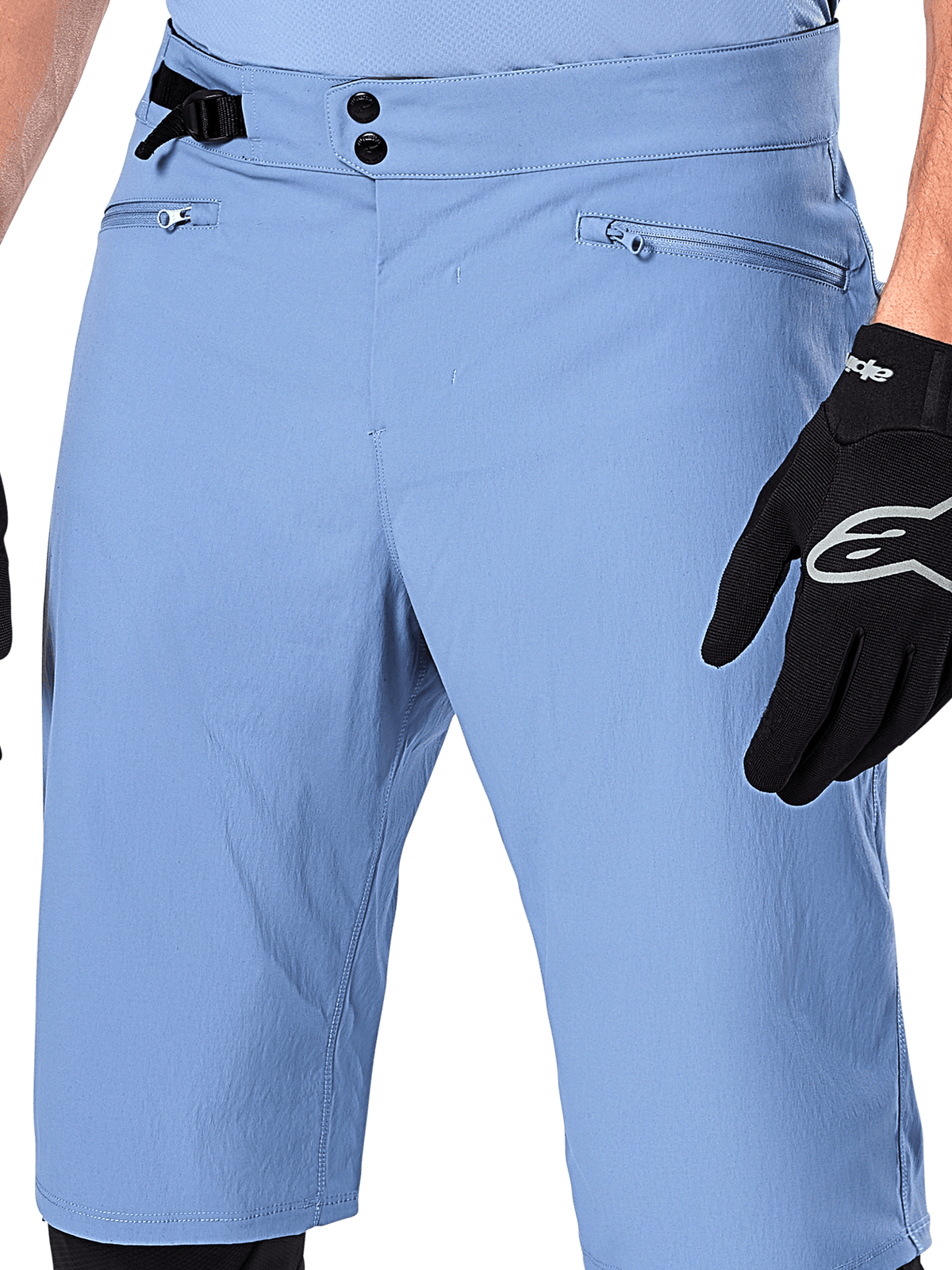 Pantaloncini Alpinestars A-Dura, shorts da mountain bike in Infinity Blue, primo piano della vita con chiusura a doppio scatto, regolazione laterale e tasche con zip foderate in rete, indossati con un guanto Alpinestars nero
