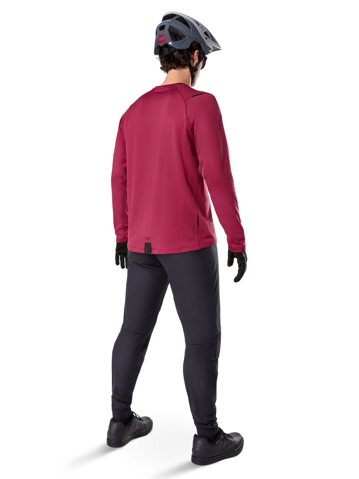 Alpinestars A-Dura Thermal Jersey, maglia da ciclismo a maniche lunghe bordeaux, vista posteriore, indossata con pantaloni da mountain bike neri e casco grigio, con bordo posteriore allungato per una maggiore copertura, equipaggiamento da mountain bike per climi freddi