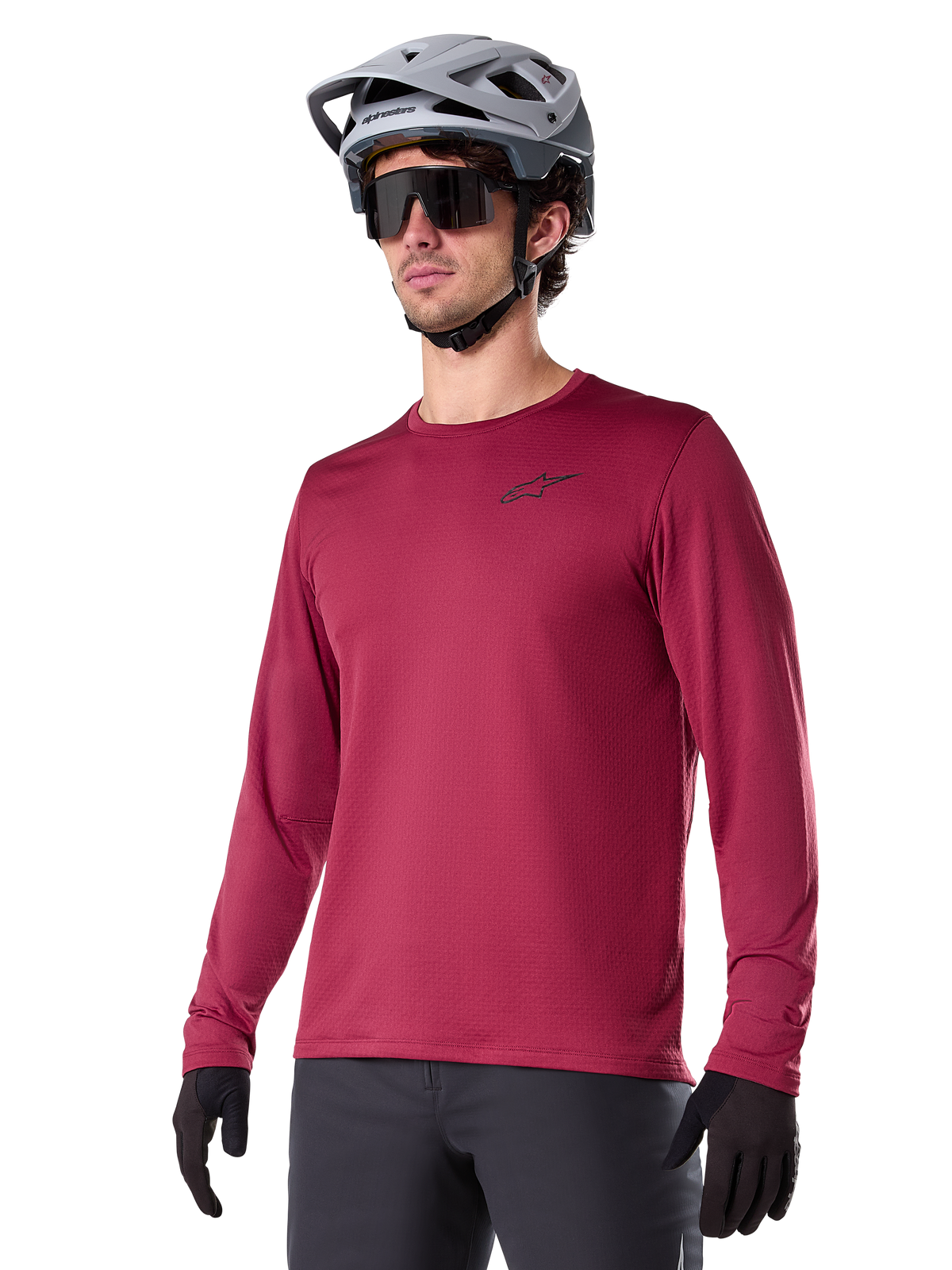 Alpinestars A-Dura Thermal Jersey, maglia da mountain bike a maniche lunghe, rosso burgundy, con fodera in pile isolante e piccolo logo nero sul petto, indossata con casco grigio, occhiali da sole neri e guanti neri, progettata per il ciclismo in climi freddi