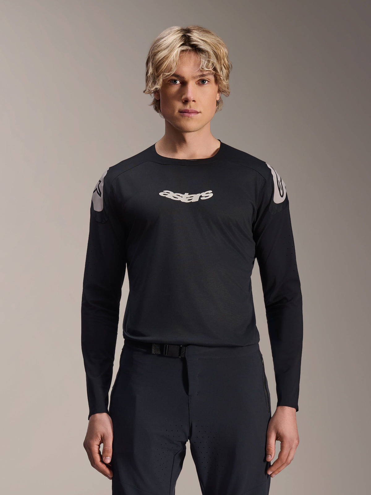 Alpinestars A-Aria Polartec Elite Jersey, maglia MTB a maniche lunghe, nera, con logo 'astars' bianco sul petto e grafiche bianche sulle spalle, abbigliamento tecnico da ciclismo indossato da un modello