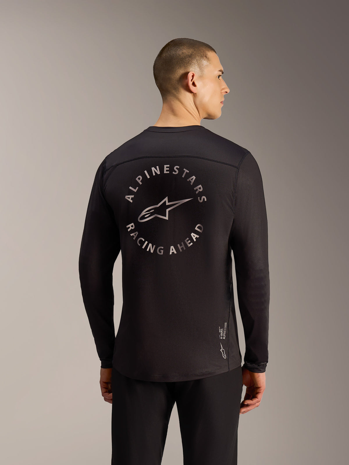Maglia A-Dura Air LS nera, vista posteriore con grafica Alpinestars Racing Ahead e tessuto mesh traspirante.