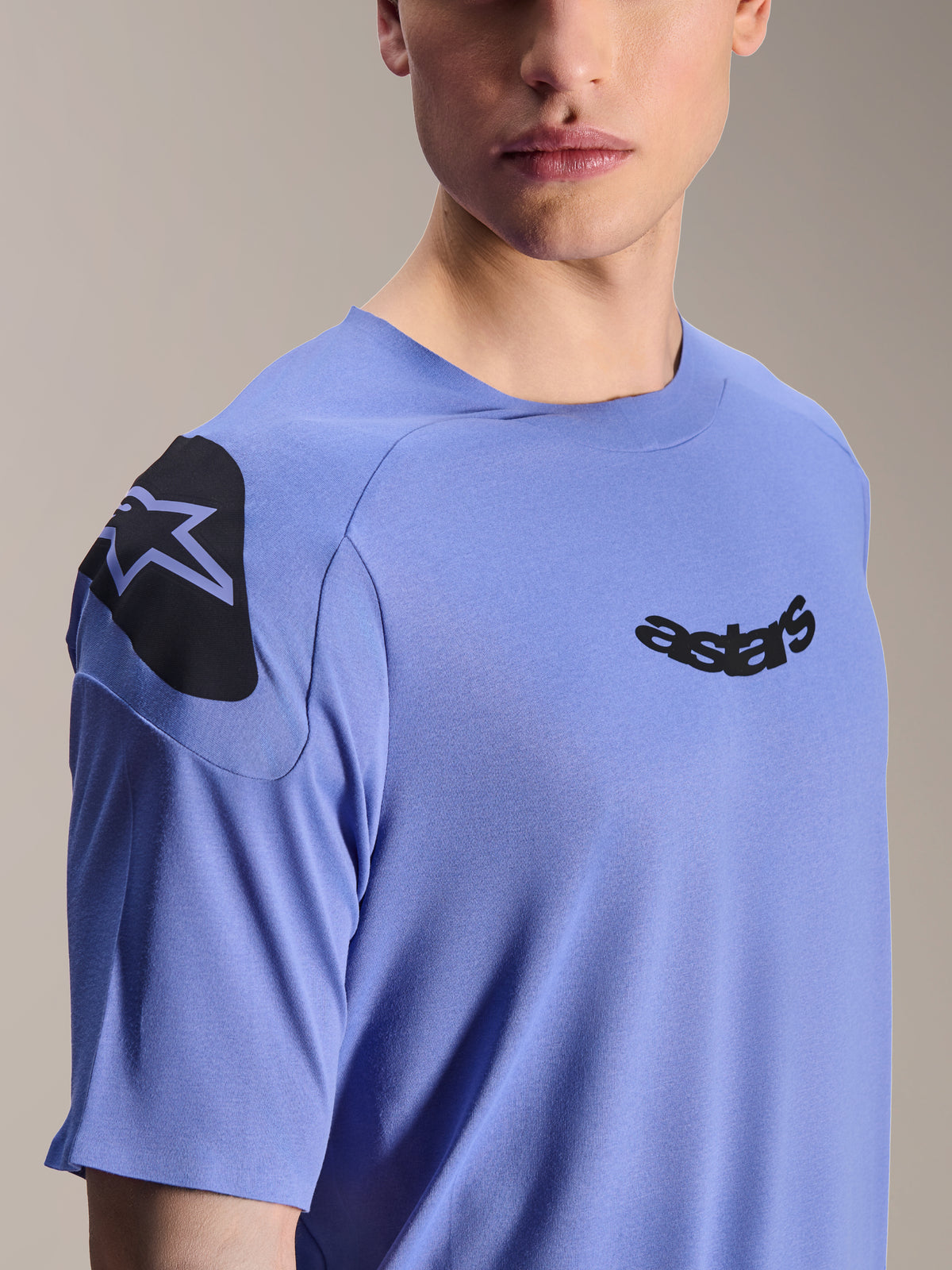 Alpinestars Maglia A-Aria Polartec Elite, maglia da mountain bike a maniche corte, Baja Blue, primo piano del petto e della spalla con logo astars nero e grafica sulla spalla, tessuto tecnico traspirante per ciclismo fuoristrada