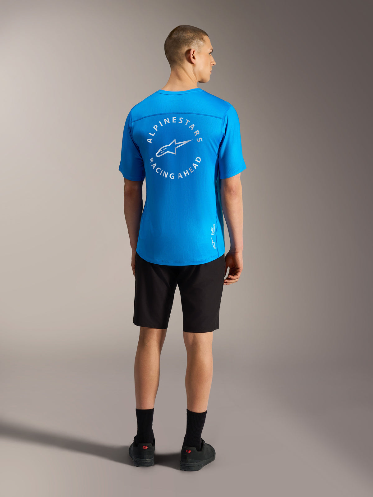 Maglia blu Alpinestars A-Dura Air SS con logo bianco sul retro e pantaloncini neri A-Dura Ride per mountain bike.