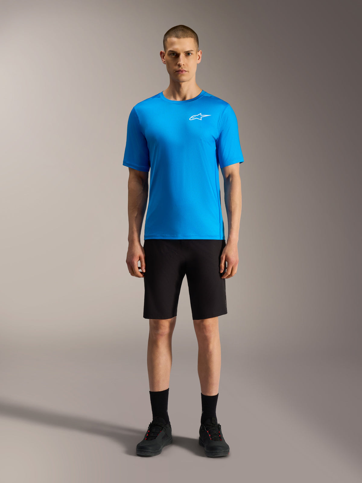 Pantaloncini Alpinestars A-Dura Ride neri e maglia blu acceso, abbigliamento MTB performante per ciclismo.