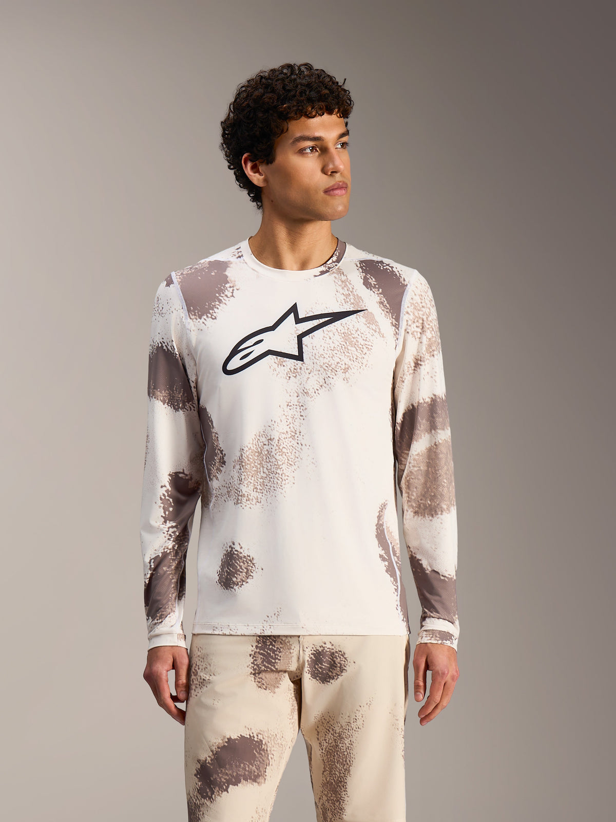 Alpinestars A-Dura Ride Maglia maniche lunghe Sand Camo, top MTB bianco con motivi astratti e logo nero sul petto.