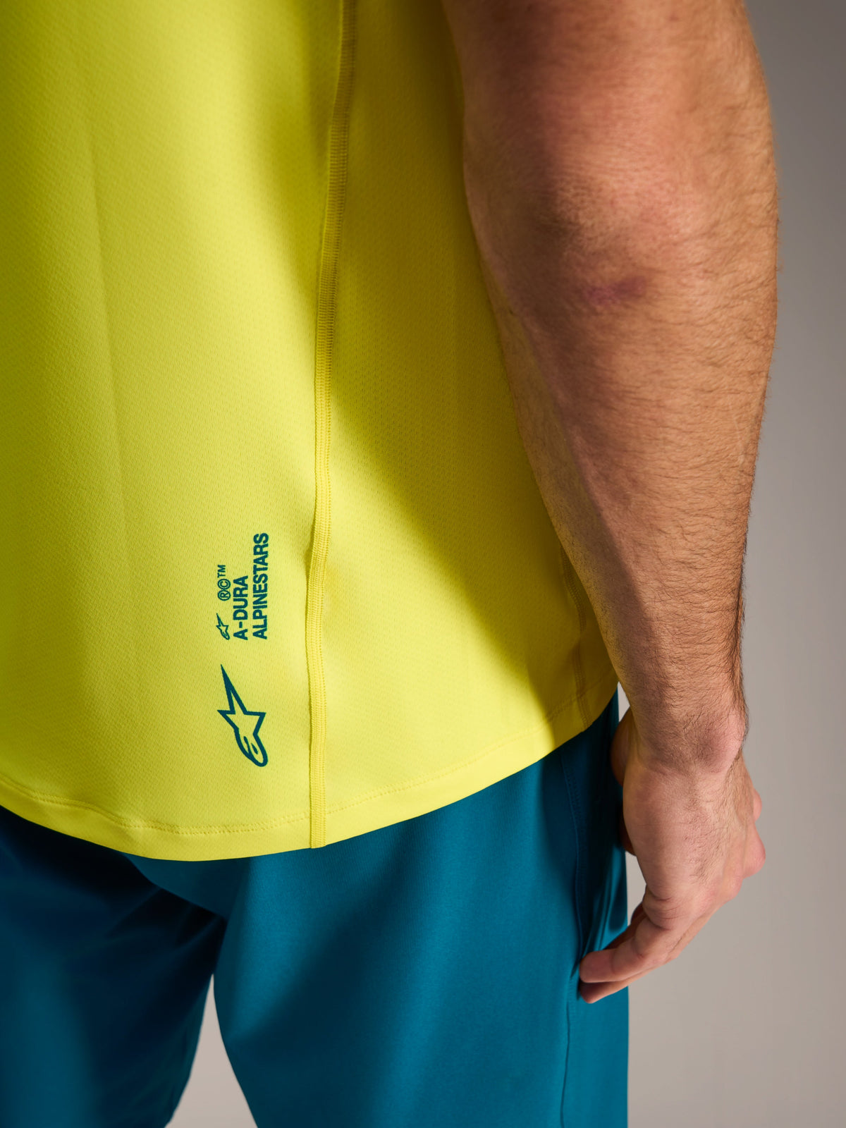 Maglia A-Dura Ride giallo fluo con marchio Alpinestars sulla parte bassa del retro, abbigliamento leggero da MTB.