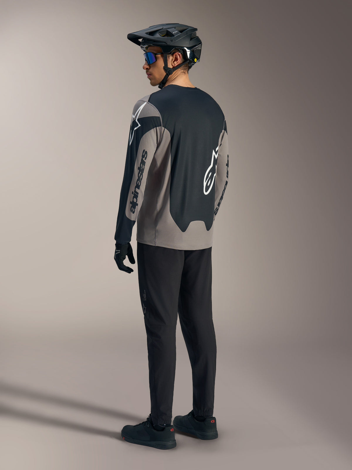 Maglia A-Dura Race a maniche lunghe grigia e nera Alpinestars, vista posteriore in un kit completo da MTB.