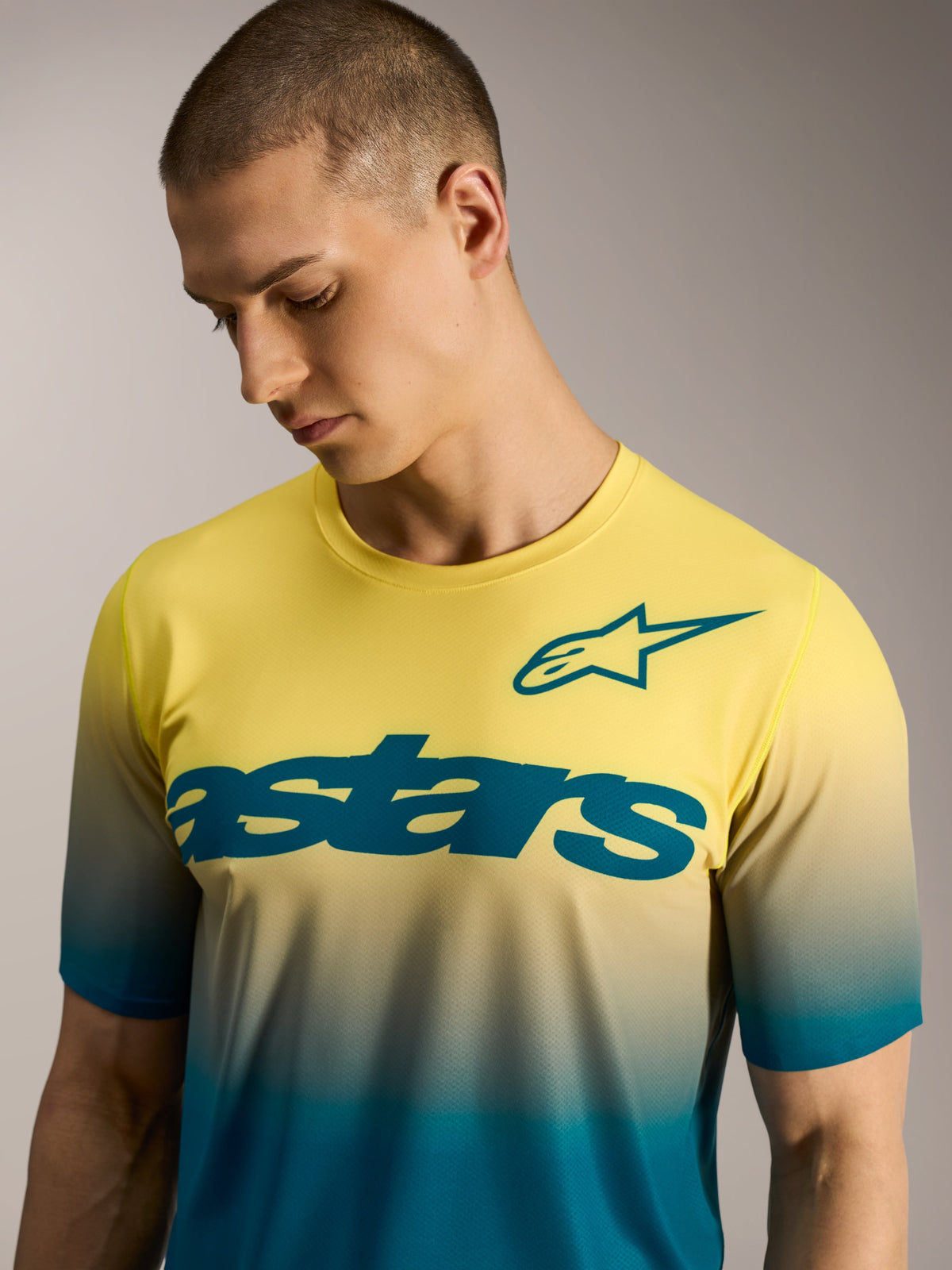 Maglia MTB A-Dura ASTARS 2.0 a maniche corte con sfumatura giallo-blu, logo a stella e scritta sul petto.