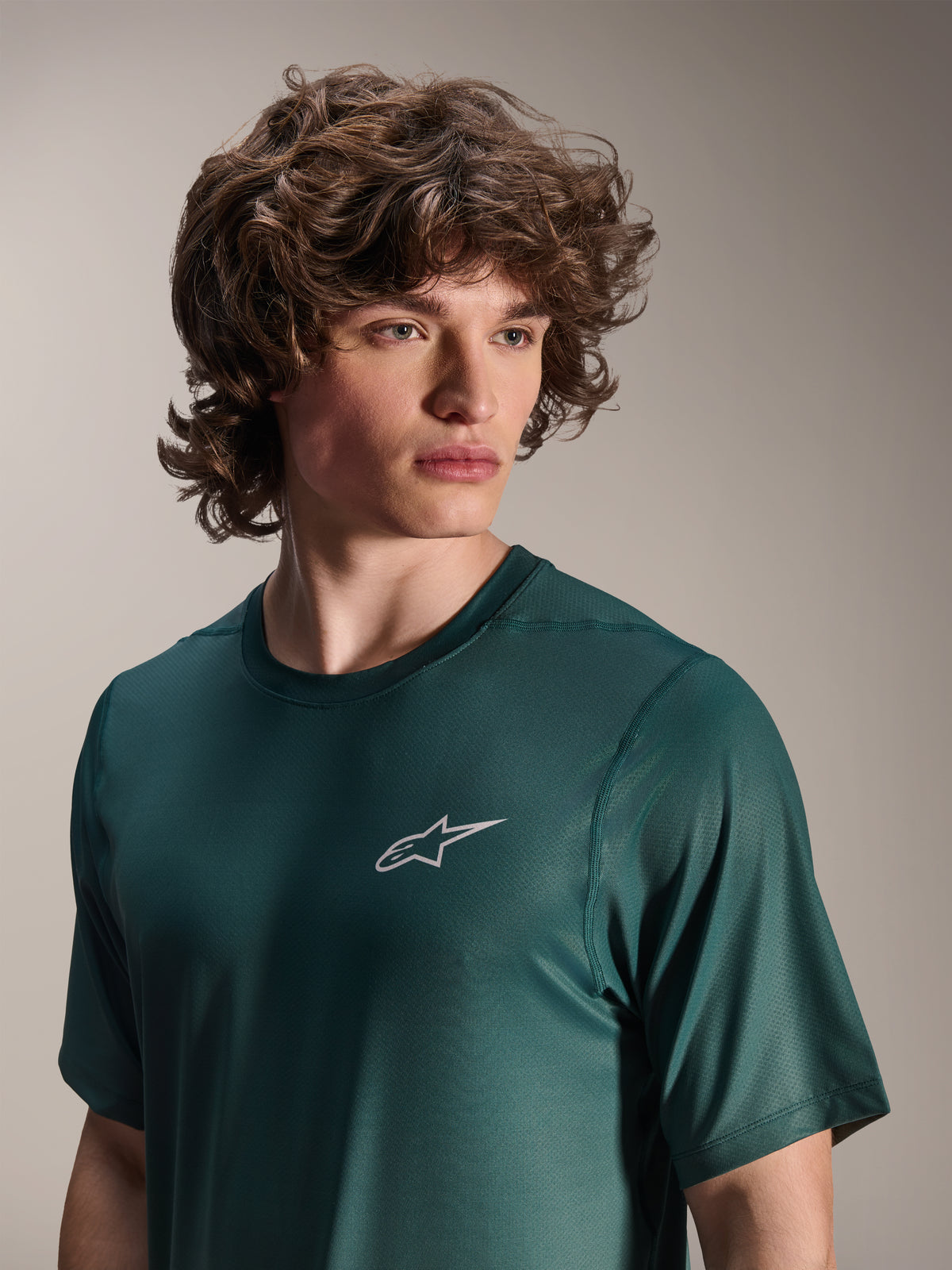 Alpinestars A-Dura Rise Jersey a maniche corte, verde Silver Pine, indossata da un modello, piccolo logo Astars bianco sul petto, tessuto tecnico jacquard, abbigliamento casual per mountain bike