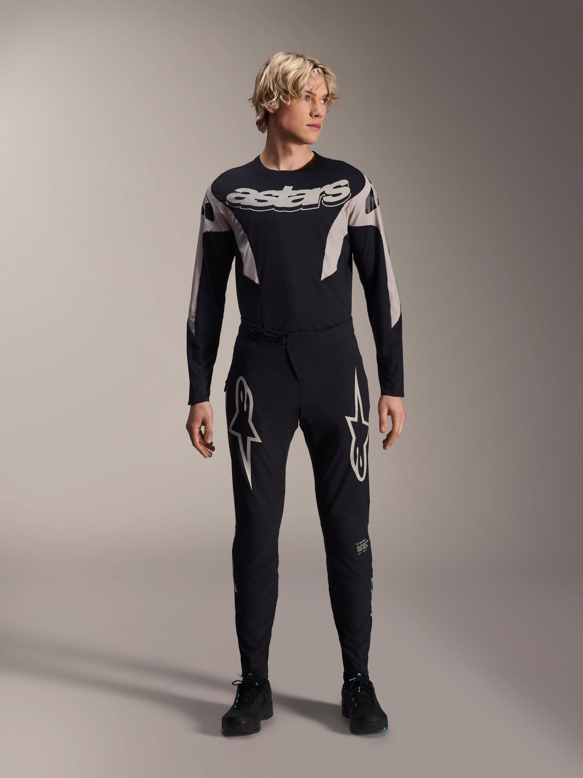 Alpinestars Maglia A-Supra Melt, maglia da MTB a maniche lunghe, nera con marchio Astars bianco sul petto, indossata con pantaloni da mountain bike neri coordinati con loghi a stella, abbigliamento tecnico da ciclismo ad alte prestazioni