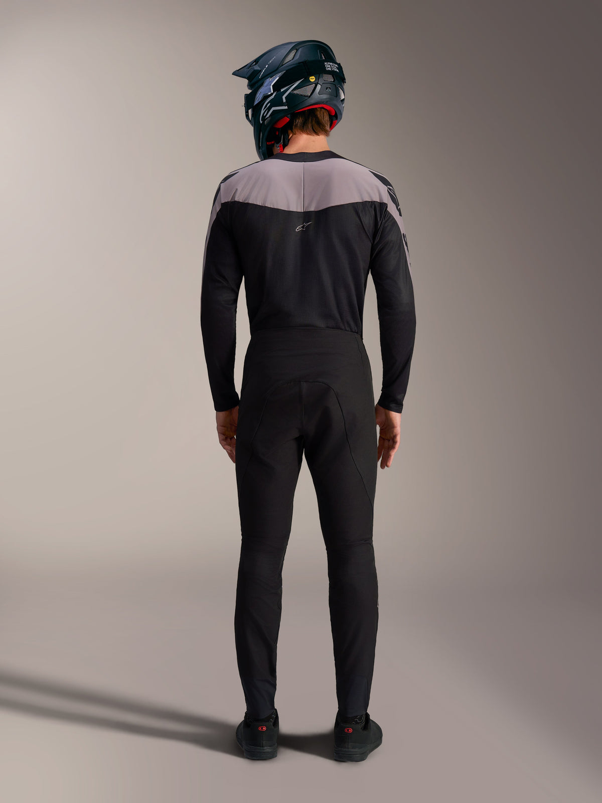 Kit MTB Alpinestars A-Supra Elite nero con maglia, pantaloni tecnici e casco integrale, vista posteriore.
