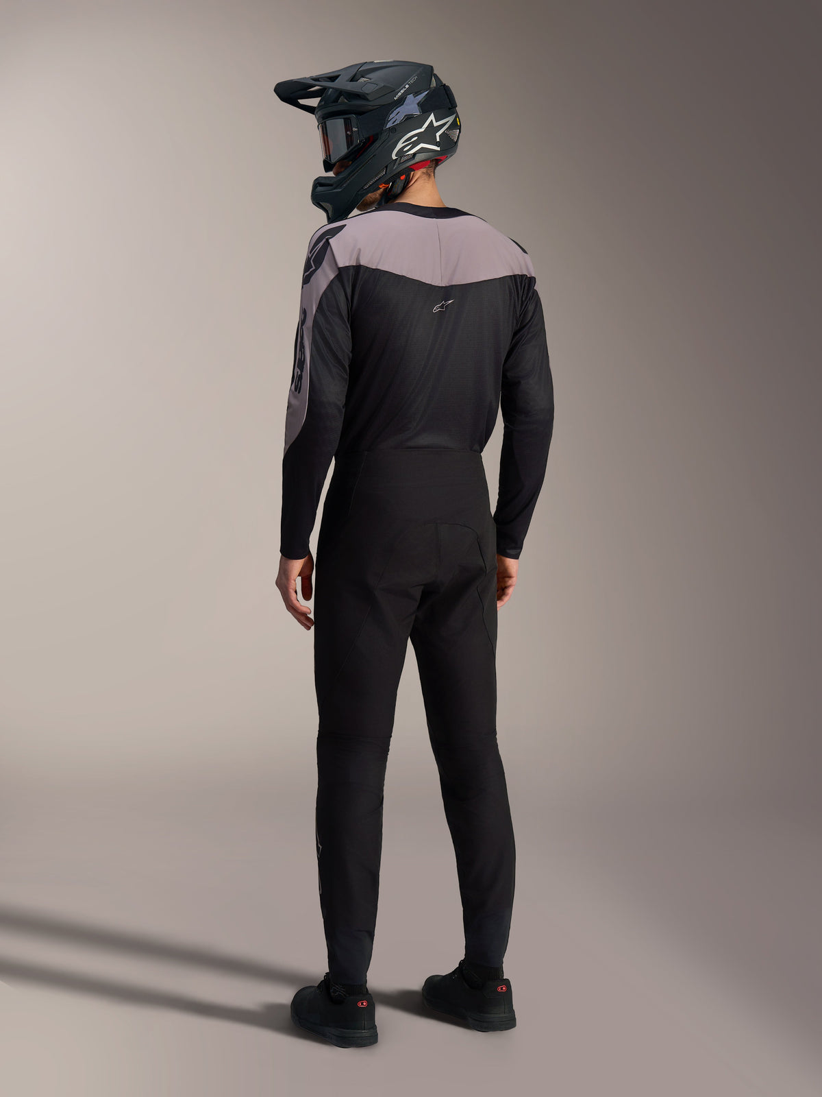 Kit MTB Alpinestars A-Supra Elite nero e grigio con maglia performance e pantaloni da gara coordinati visti dal retro.
