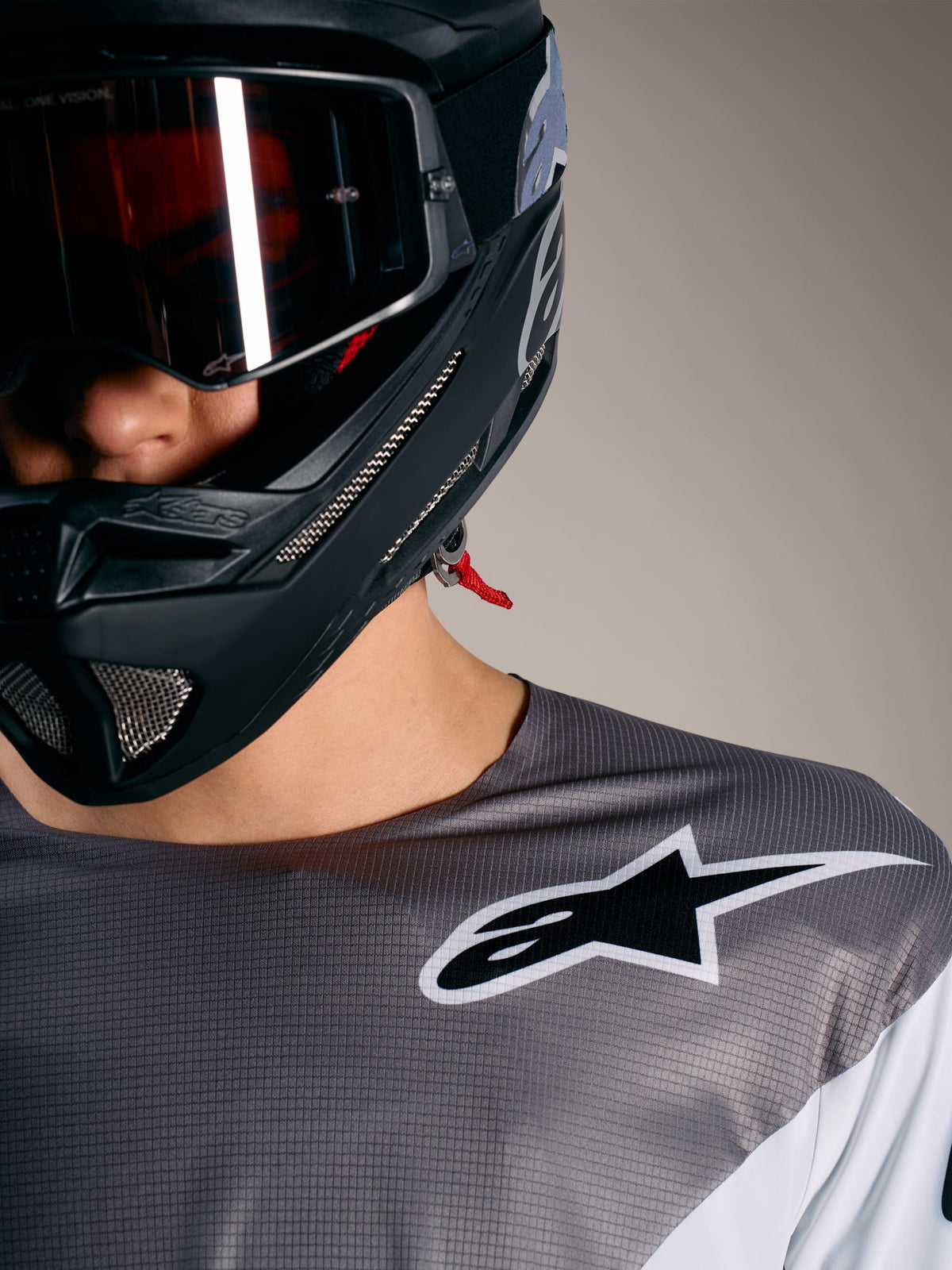 Maglia Alpinestars A-Supra Elite in Faded Gray, tessuto microforato, logo bianco e casco da MTB nero.