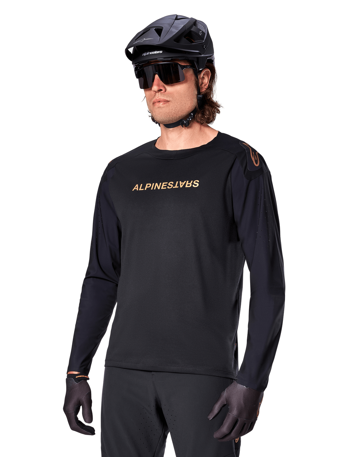 Alpinestars Maglia A-Aria Polartec Switch a maniche lunghe, nero con logo oro, abbigliamento per mountain bike MTB, indossata con casco nero e occhiali da sole, con ventilazione tagliata al laser sulle maniche e tessuto Polartec traspirante per prestazioni off-road