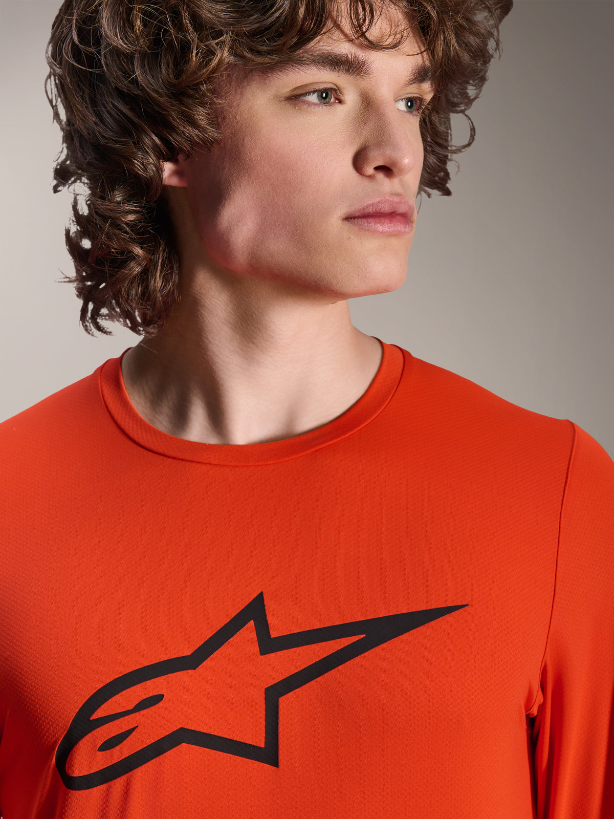 Maglia Alpinestars A-Dura Insert Astar, maglia MTB a maniche lunghe, Spicy Orange, con logo Alpinestars Astar nero sul petto, vista ravvicinata su un modello maschile