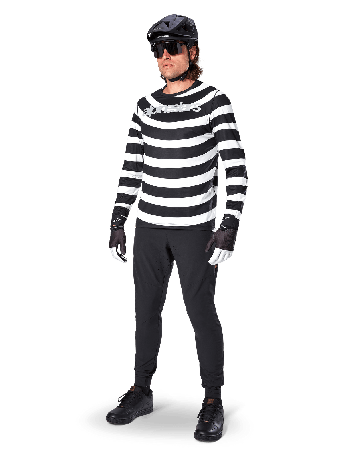Alpinestars A-Aria Oscar Long Sleeve Jersey, maglia a maniche lunghe, nero e bianco con audaci strisce orizzontali a spirale, logo Alpinestars bianco curvo, abbigliamento MTB da performance indossato con pantaloni da ciclismo neri e casco