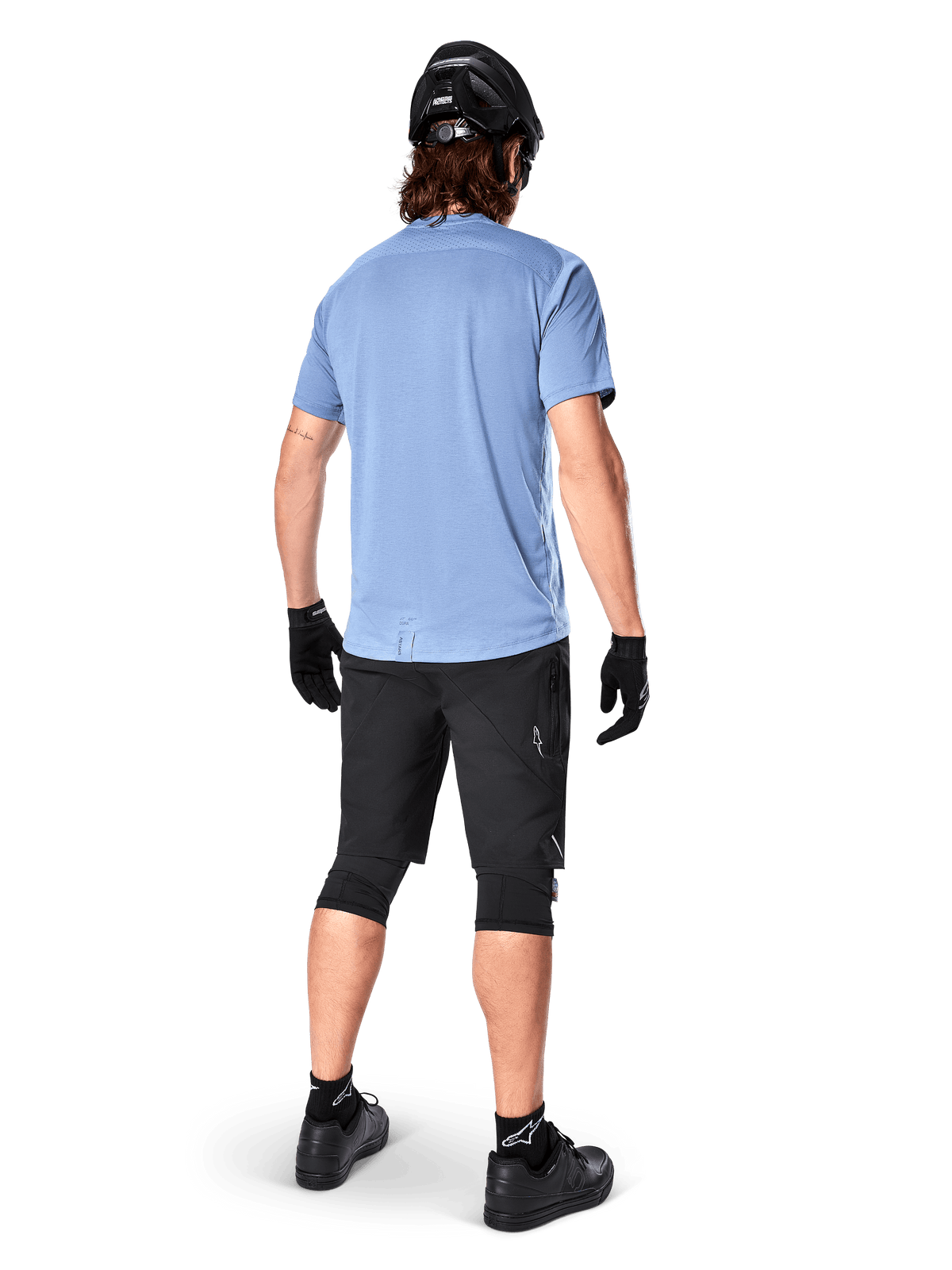 Alpinestars Maglia A-Dura Dri Astar a maniche corte, Infinity Blue, vista posteriore, abbinata a pantaloncini da mountain bike neri e casco, abbigliamento tecnico da ciclismo con tessuto traspirante e coda più lunga