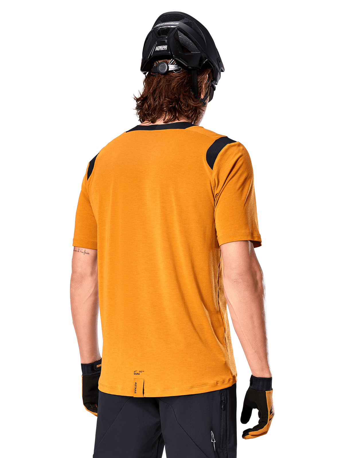 Alpinestars Maglia A-Dura Dri Wool a maniche corte, Dark Gold, vista posteriore di un uomo che indossa la maglia con pannelli in rete neri sulle spalle, abbinata a casco e guanti da MTB neri, abbigliamento da mountain bike con vestibilità regolare