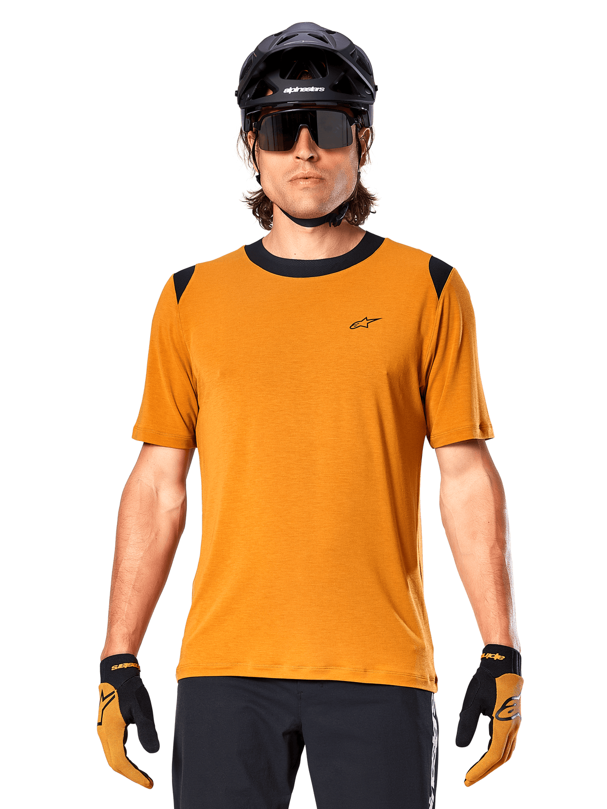 Maglia a maniche corte Alpinestars A-Dura Dri Wool, Oro Scuro, indossata con casco MTB nero, occhiali da sole e guanti, con colletto e pannelli sulle spalle neri, in misto lana traspirante drirelease per mountain bike
