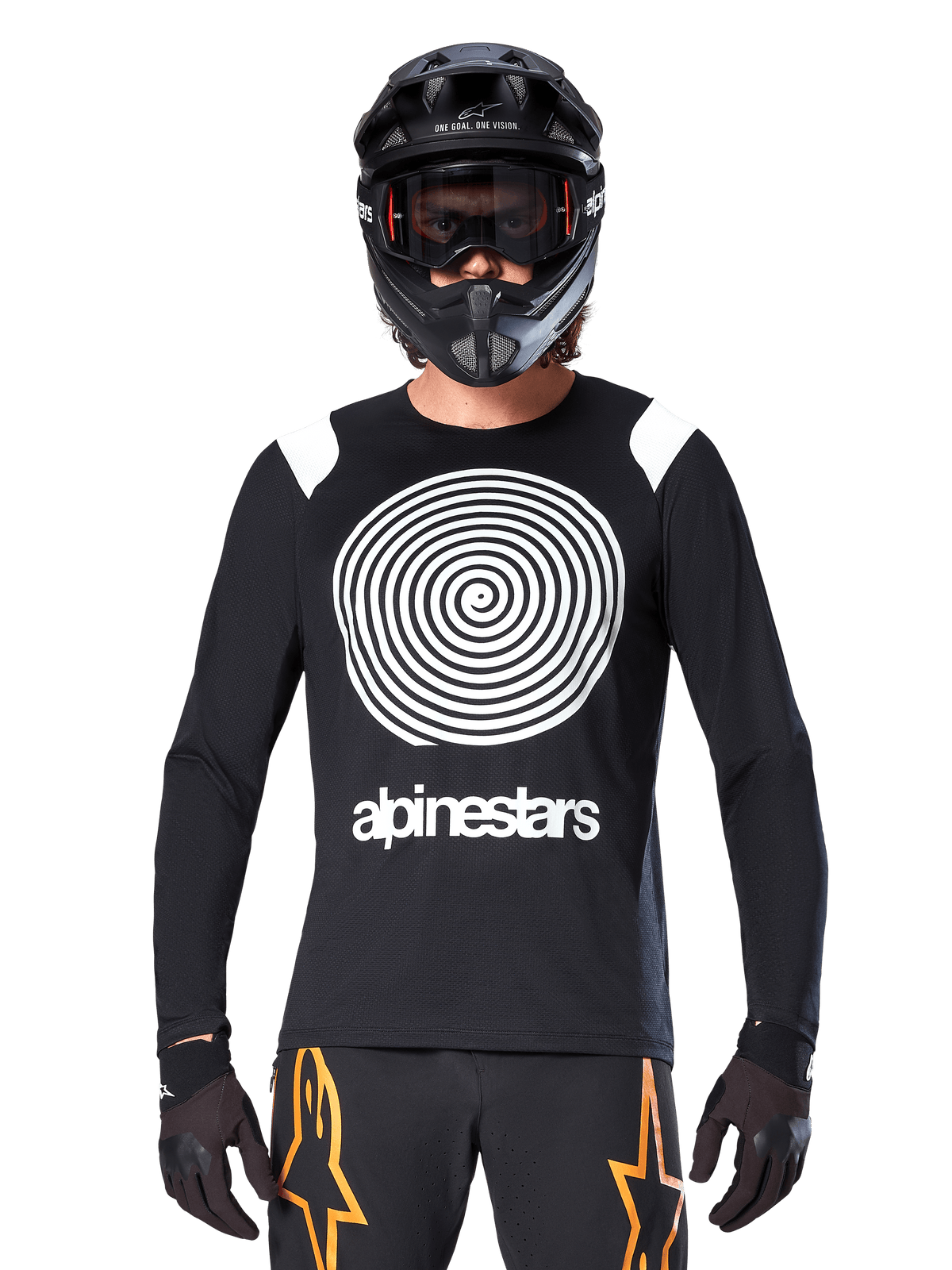 Maglia a maniche lunghe Alpinestars A-Supra Oscar, nera con grafica a spirale bianca e dettagli sulle spalle, indossata da un pilota con casco integrale nero e maschera, pantaloni neri e arancioni, abbigliamento tecnico da ciclismo per MTB gravity