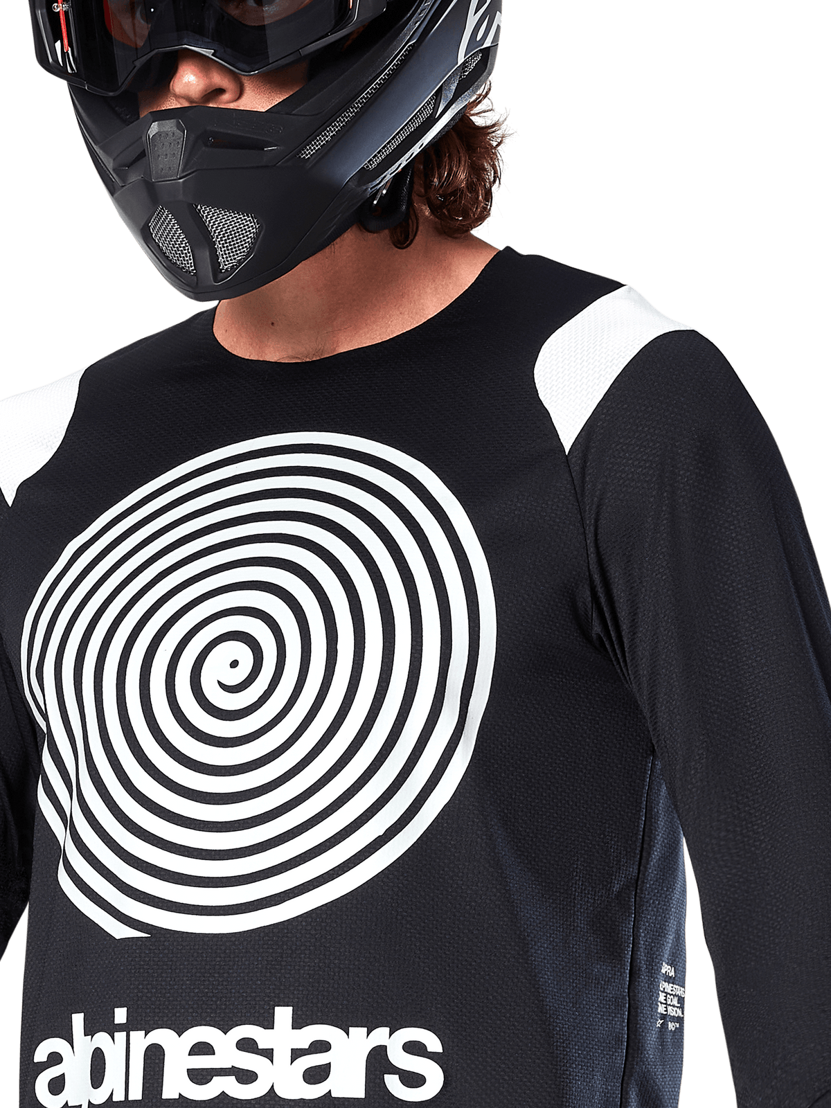 Alpinestars A-Supra Oscar Jersey, maglia a maniche lunghe, nero, con grande grafica a spirale Oscar bianca sul petto e logo del brand, indossata da un rider con casco integrale nero e maschera, abbigliamento tecnico da mountain bike per il gravity