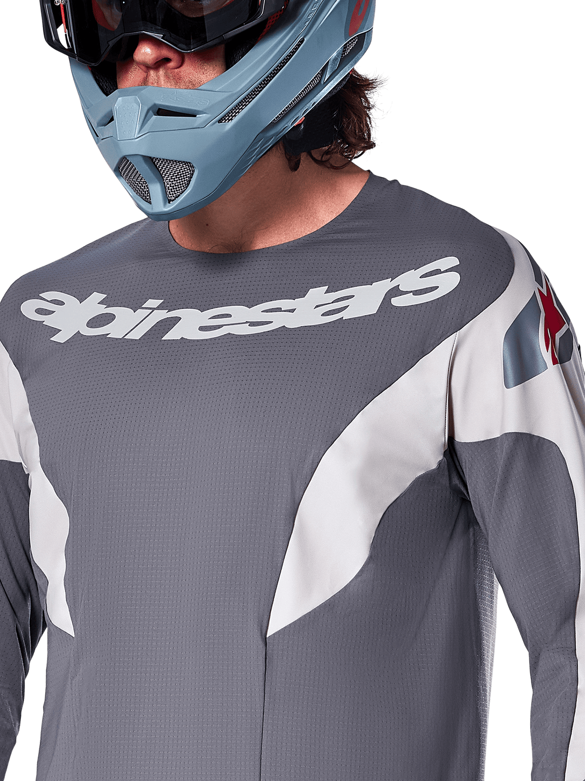 Alpinestars A-Supra Race Jersey - a maniche lunghe, maglia MTB, grigio scuro con grafiche racing bianche e logo Alpinestars bianco, indossata con casco integrale azzurro e maschera, tessuto microperforato per prestazioni off-road