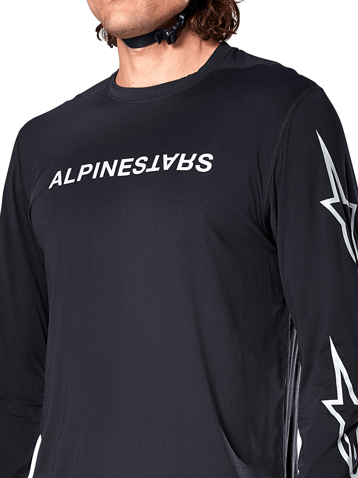 Maglia Alpinestars A-Dura Switch Long Sleeve, nero, con scritta Alpinestars bianca sul petto e loghi a stella sulla manica, indossata da un rider con cinturino del casco visibile, abbigliamento tecnico da mountain bike.