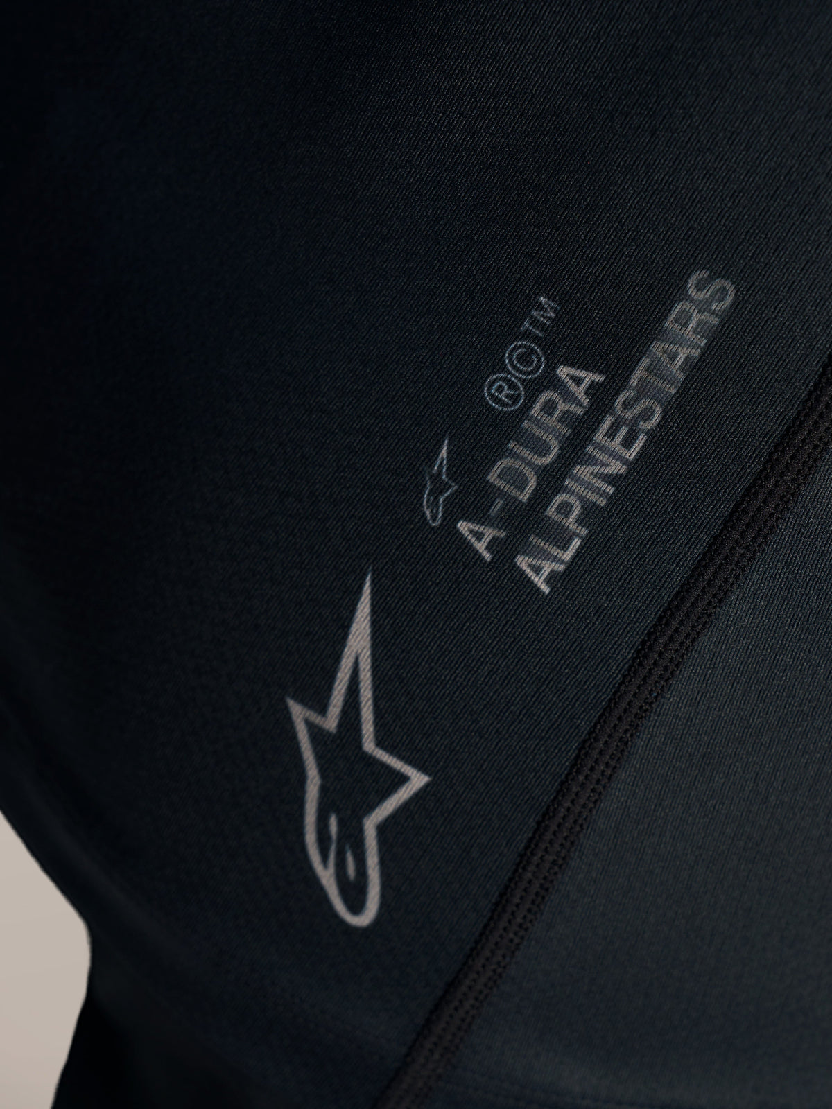 Maglia Stella A-Dura Ride nera, dettaglio del logo Alpinestars bianco e marchio A-DURA su tessuto jacquard.