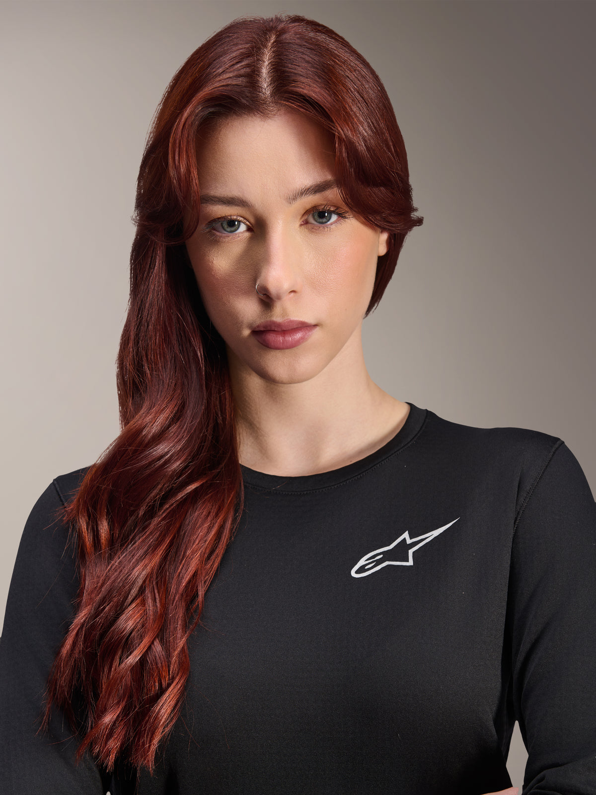 Alpinestars Stella A-Dura Thermal Jersey, maglia da MTB a maniche lunghe da donna, nero con logo A-star bianco sul petto, ritratto in primo piano di una donna con lunghi capelli rossi, abbigliamento da ciclismo per climi freschi