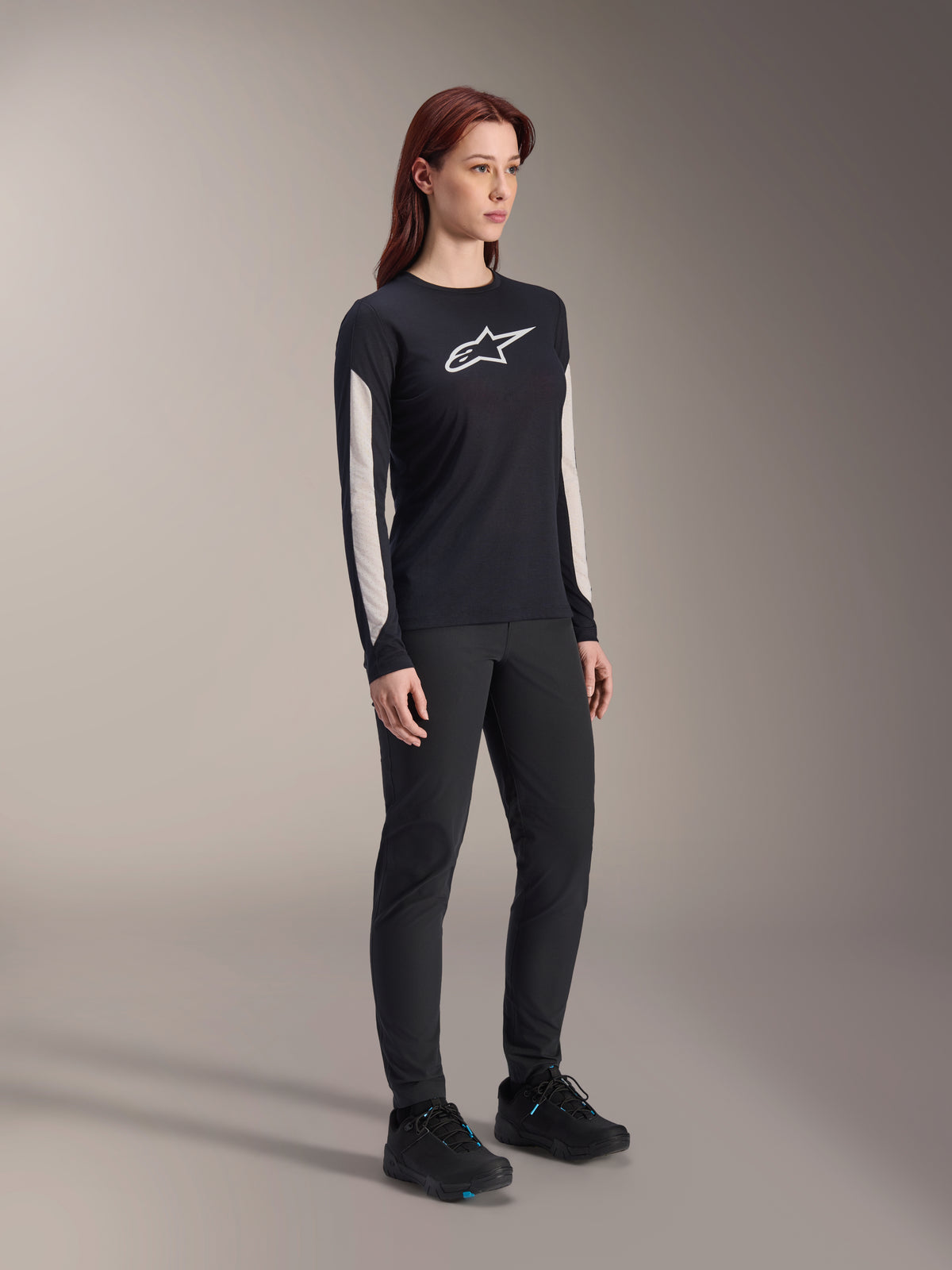 Alpinestars Maglia Stella A-Dura Dri Astar Long Sleeve da donna, nero, con pannelli in mesh bianco sulle maniche e logo Astar bianco, indossata con pantaloni e scarpe neri, abbigliamento tecnico da ciclismo per mountain bike