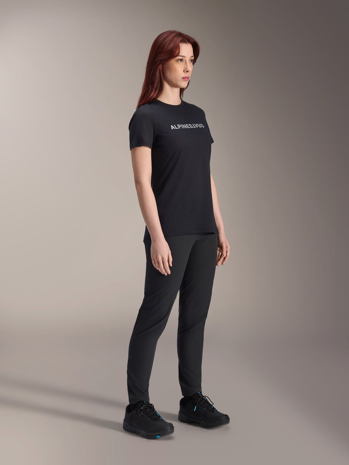 Alpinestars Stella A-Dura Dri Switch Jersey, maglia da ciclismo a maniche corte, nera con logo Alpinestars bianco, indossata da una modella con pantaloni e scarpe neri coordinati, abbigliamento versatile per mountain bike.