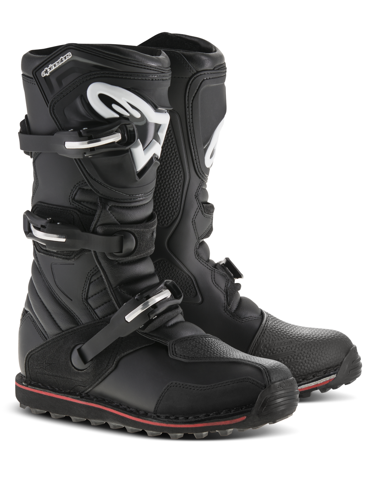 Alpinestars Tech-T Boots, stivali da moto da trial, nero con accenti rossi e bianchi, sistema di chiusura a tre fibbie, placca tibiale ergonomica con logo Astars bianco, sottile striscia rossa lungo la suola, robusta struttura in pelle per il trial e la guida fuoristrada