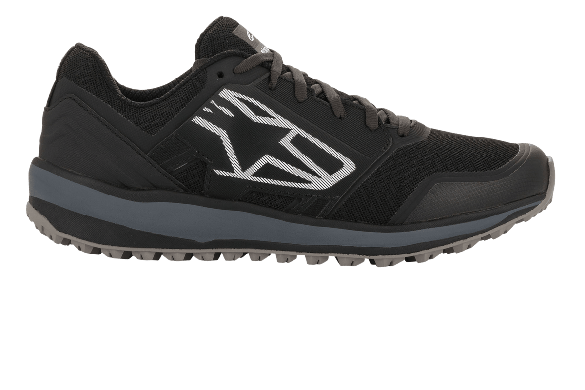 Scarpe Alpinestars Meta Trail, scarpe da running ad alte prestazioni, nero e grigio scuro, vista laterale con grande logo geometrico Astars bianco, tomaia in mesh con intersuola grigia e suola in gomma tassellata, calzature casual da paddock