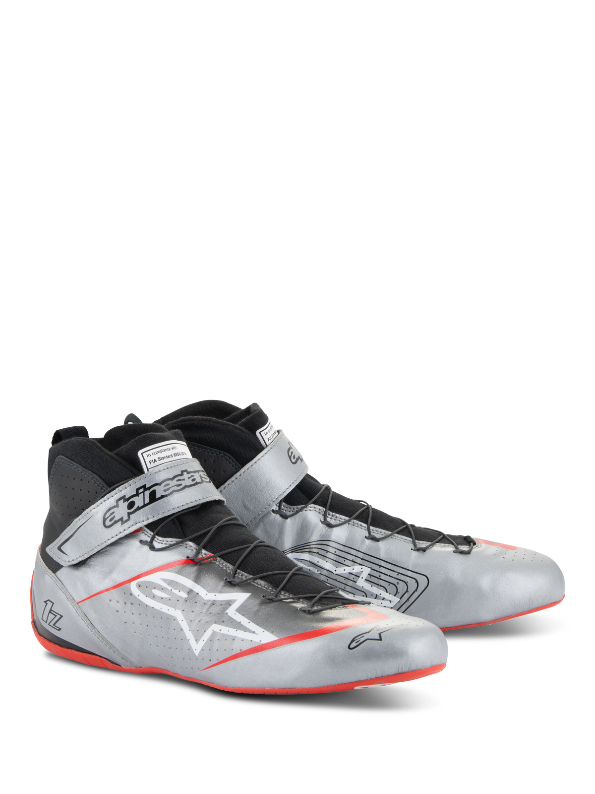 Alpinestars Scarpe Tech-1 Z V3 FIA, scarpe per corse automobilistiche, argento scuro con dettagli neri e rossi, tomaia in pelle argento metallizzato con sistema di allacciatura rapida nero, cinturino alla caviglia logato e suola sottile con dettagli rossi.