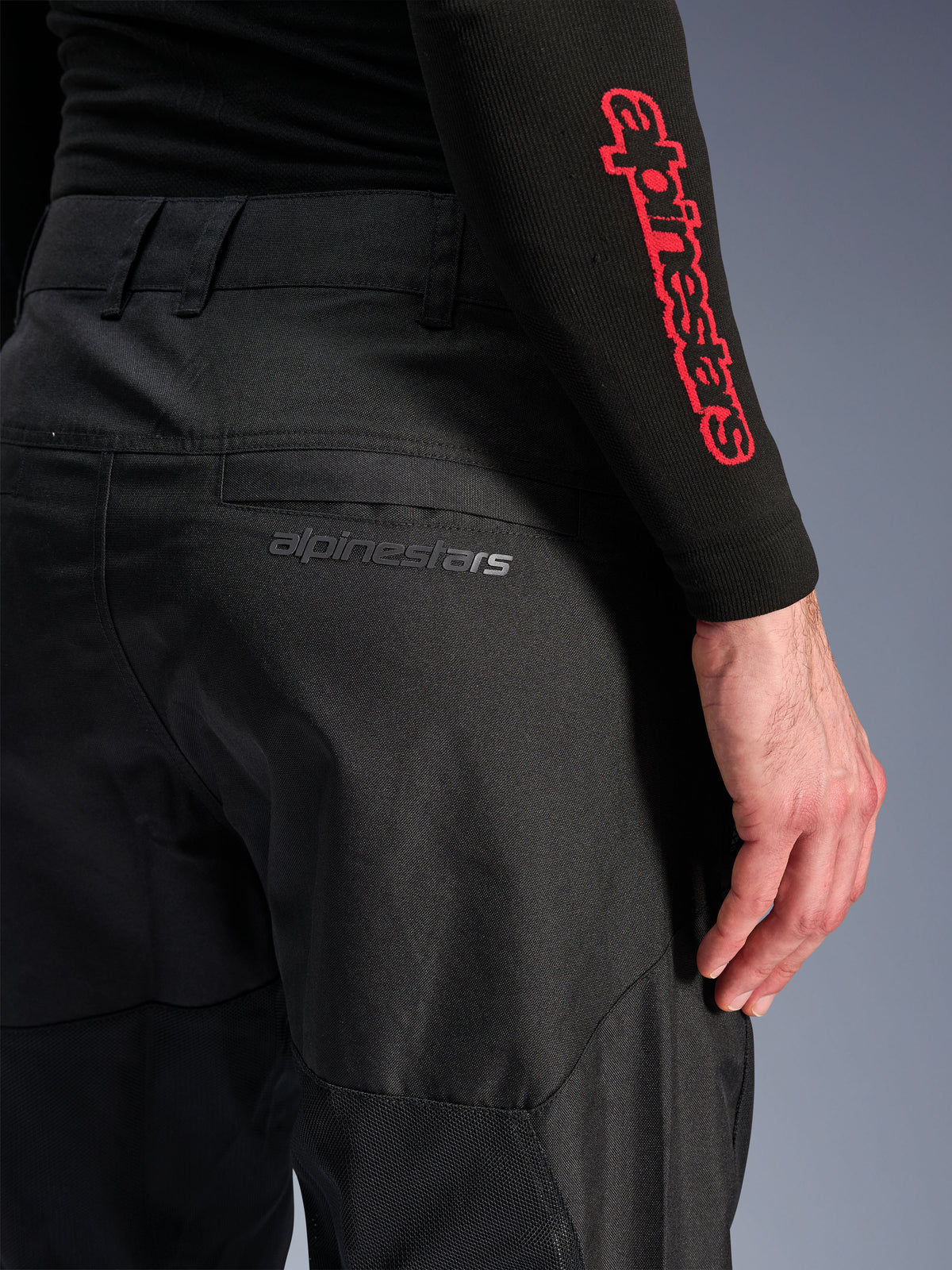 Alpinestars C-1 Air Pants, pantaloni da moto in tessuto nero, vista ravvicinata della tasca posteriore con un discreto logo Alpinestars grigio, con pannelli in rete traspirante e poly-tessuto resistente, progettati per il comfort nella guida urbana