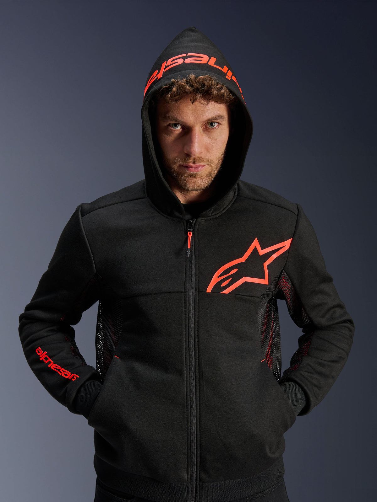Alpinestars Chrome Air Sport Hoodie, felpa da moto urbana, nero e rosso fluo, con pannelli di ventilazione in mesh, logo Astar rosso sul petto e cappuccio logato, abbigliamento casual per ambienti urbani.