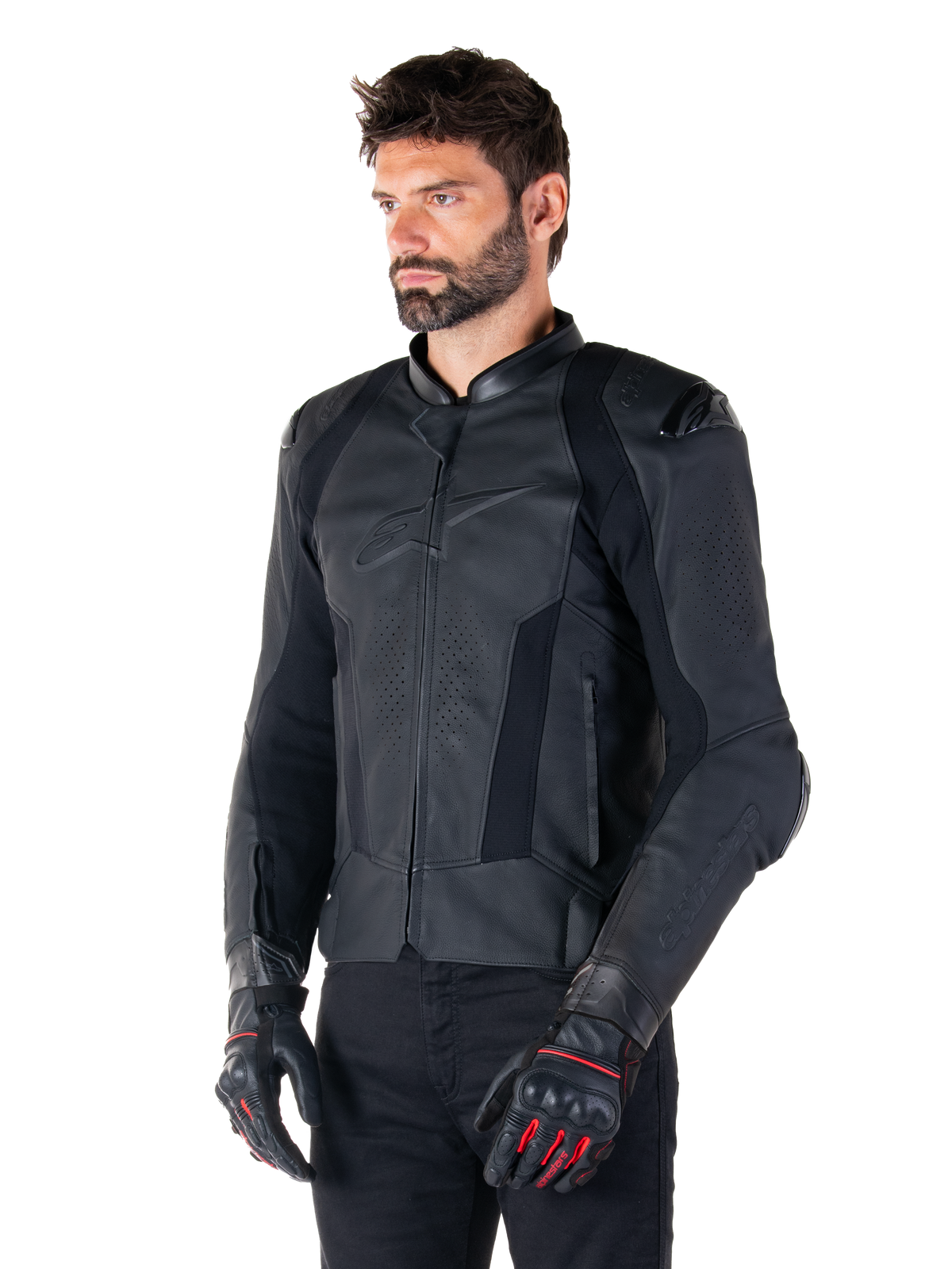 Motociclista con giacca in pelle Alpinestars Missile V3 in nero, in pregiata pelle bovina con pannelli traforati sul petto e protezioni esterne DFS sulle spalle, abbinata a pantaloni neri e guanti da corsa neri e rossi.