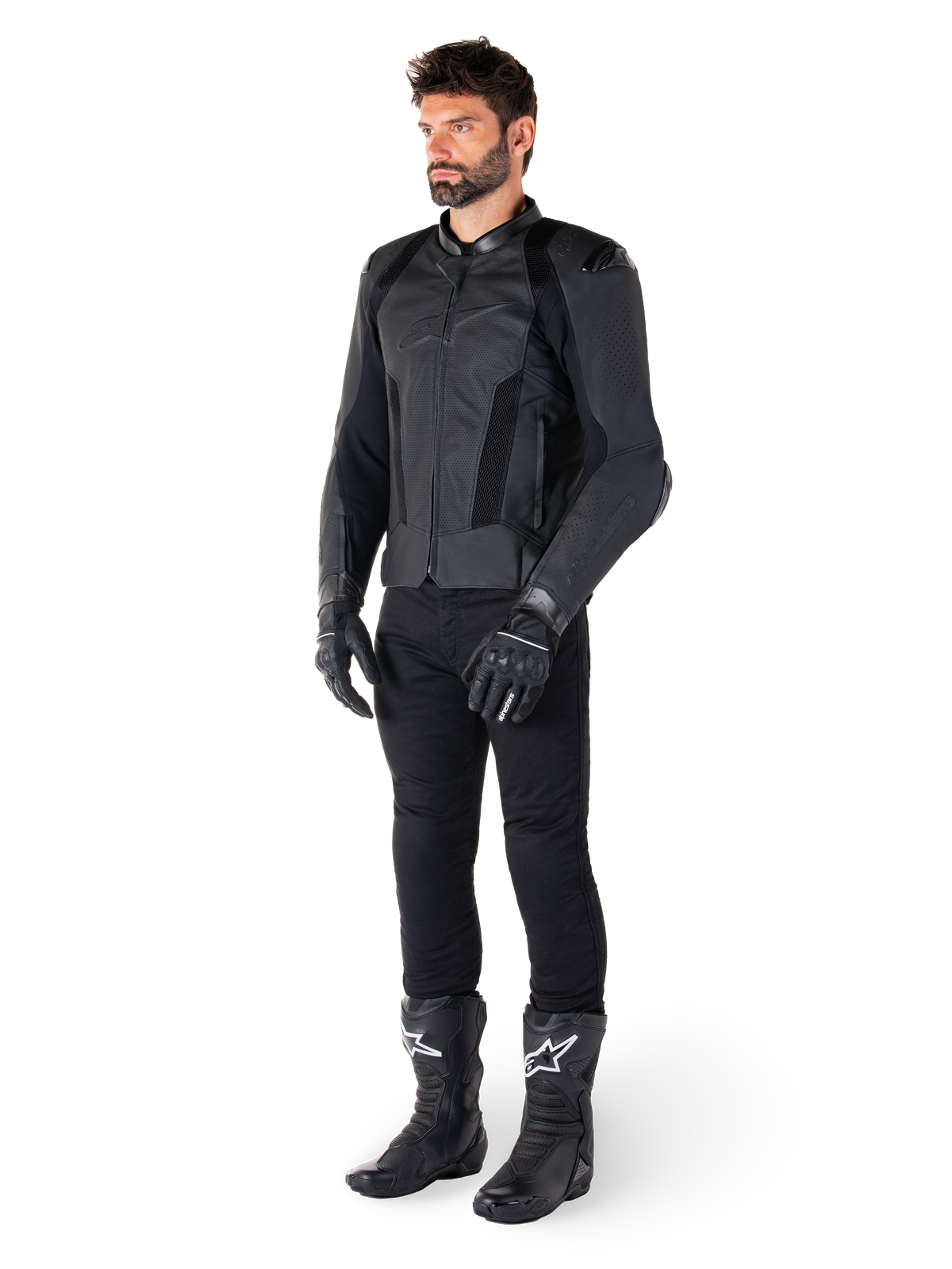 Alpinestars Missile V3 Airflow Leather Jacket, nero, indossata da un pilota con pantaloni, guanti e stivali neri coordinati, con pelle bovina traforata per la massima ventilazione e protezioni DFS sulle spalle, abbigliamento da moto sportivo premium