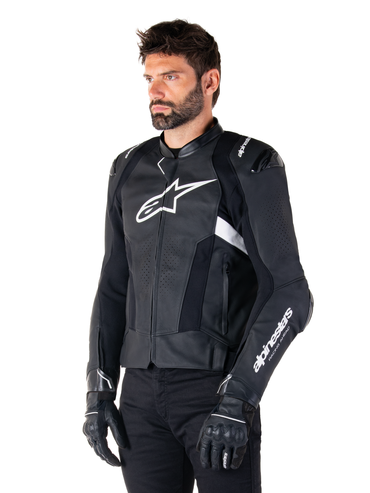 Uomo che indossa la giacca in pelle Alpinestars Missile V3 Airflow, giacca da moto in nero e bianco, pelle pregiata traforata per il flusso d'aria, logo Alpinestars bianco su petto e manica, vestibilità sportiva ispirata alle corse, indossata con guanti e pantaloni neri.