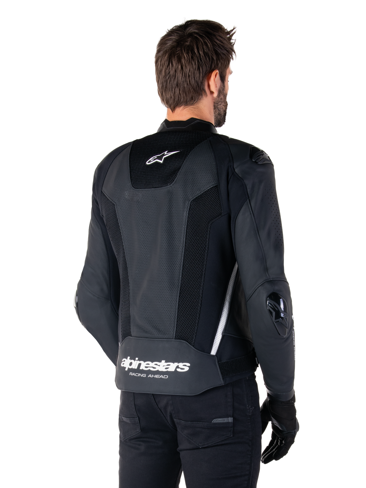 Alpinestars Missile V3 Airflow Leather Jacket, nero e bianco, vista posteriore con pelle traforata e pannelli in rete per la massima ventilazione, marchio Alpinestars bianco sulla parte inferiore della schiena e logo a stella sul collo, indossata con abbigliamento da moto nero, design sportivo racing premium.