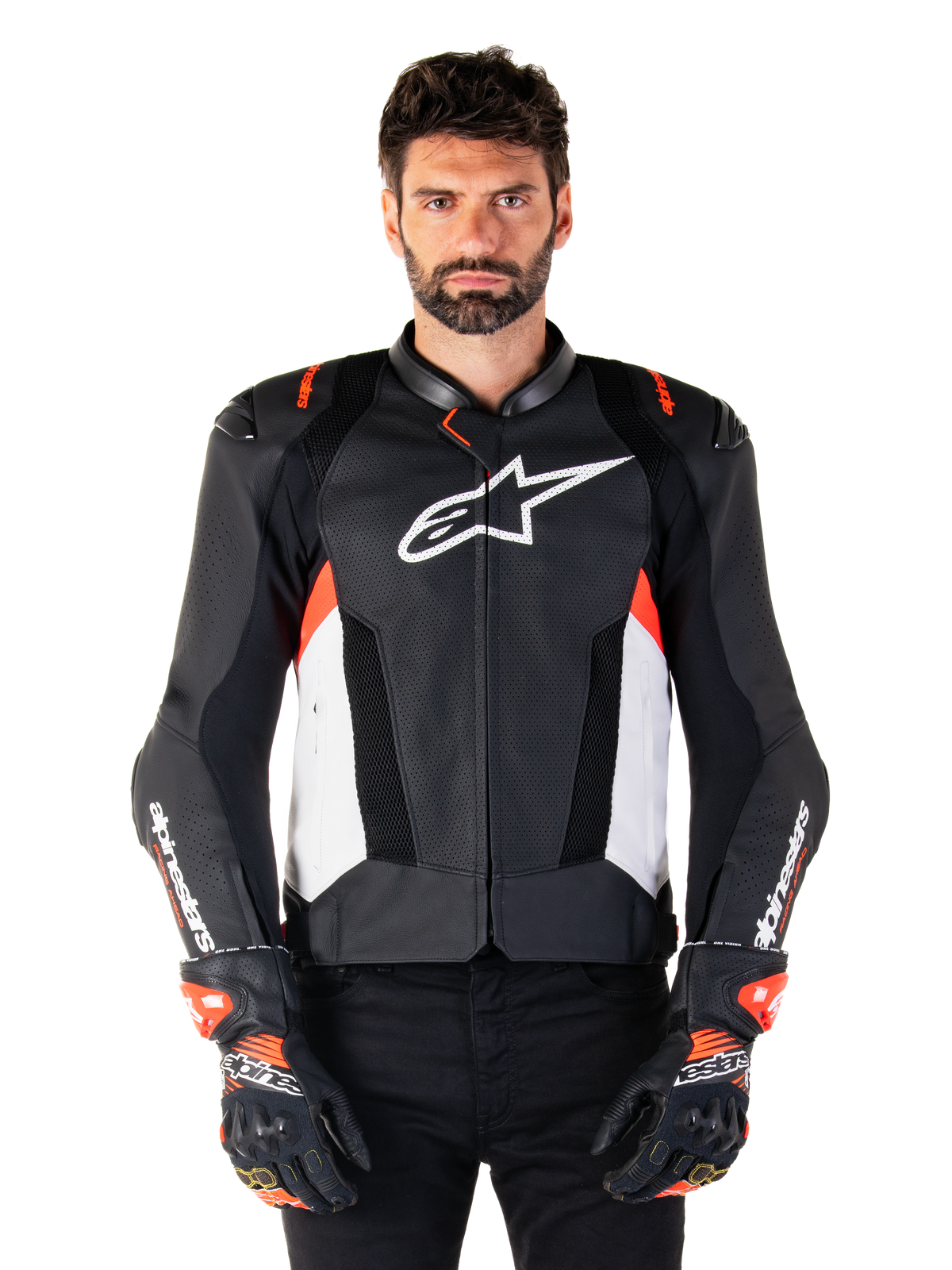 Giacca Alpinestars Missile V3 Airflow in pelle, giacca da moto racing, nero e bianco con accenti rosso fluo, pannelli di ventilazione traforati, logo stella bianco sul petto, indossata con guanti neri e rossi, costruzione in pelle pregiata