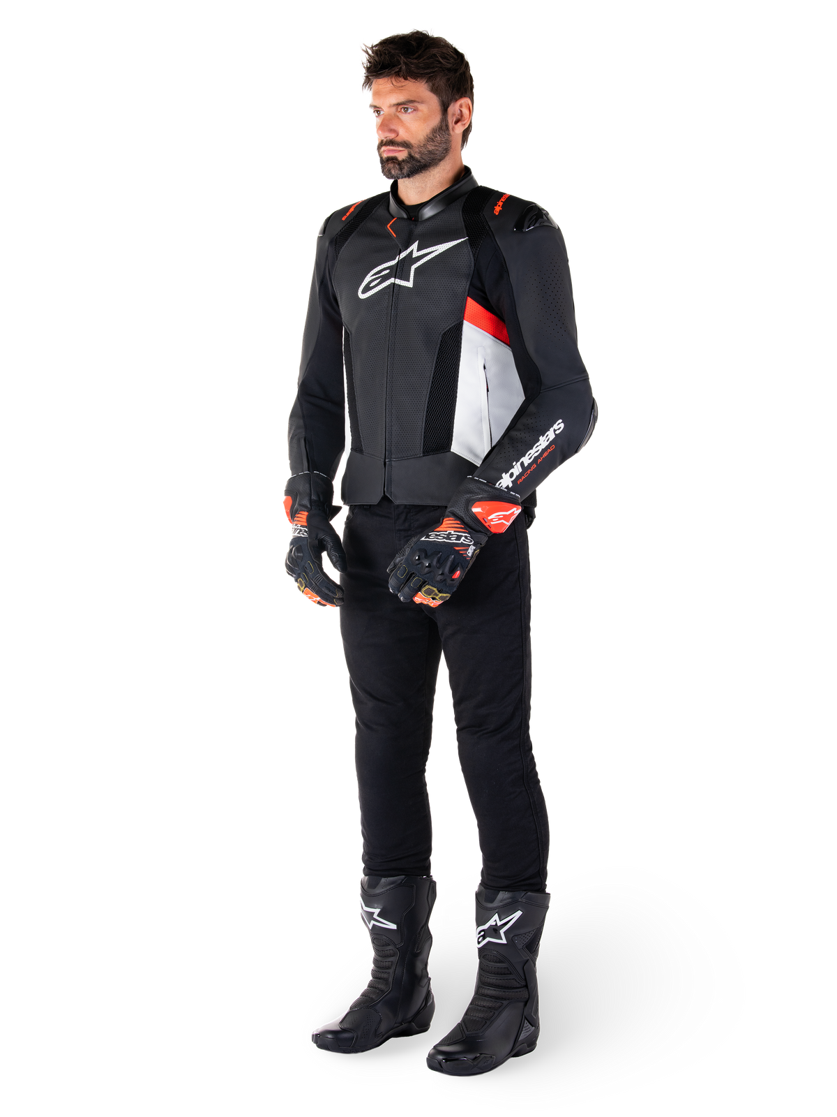 Giacca in pelle Alpinestars Missile V3 Airflow, nero bianco rosso fluo, indossata da un modello con pantaloni neri, guanti da corsa neri e stivali neri, caratterizzata da pelle traforata per la ventilazione, logo bianco sul petto e accenti rosso fluo, progettata per prestazioni racing e sportive di alto livello.