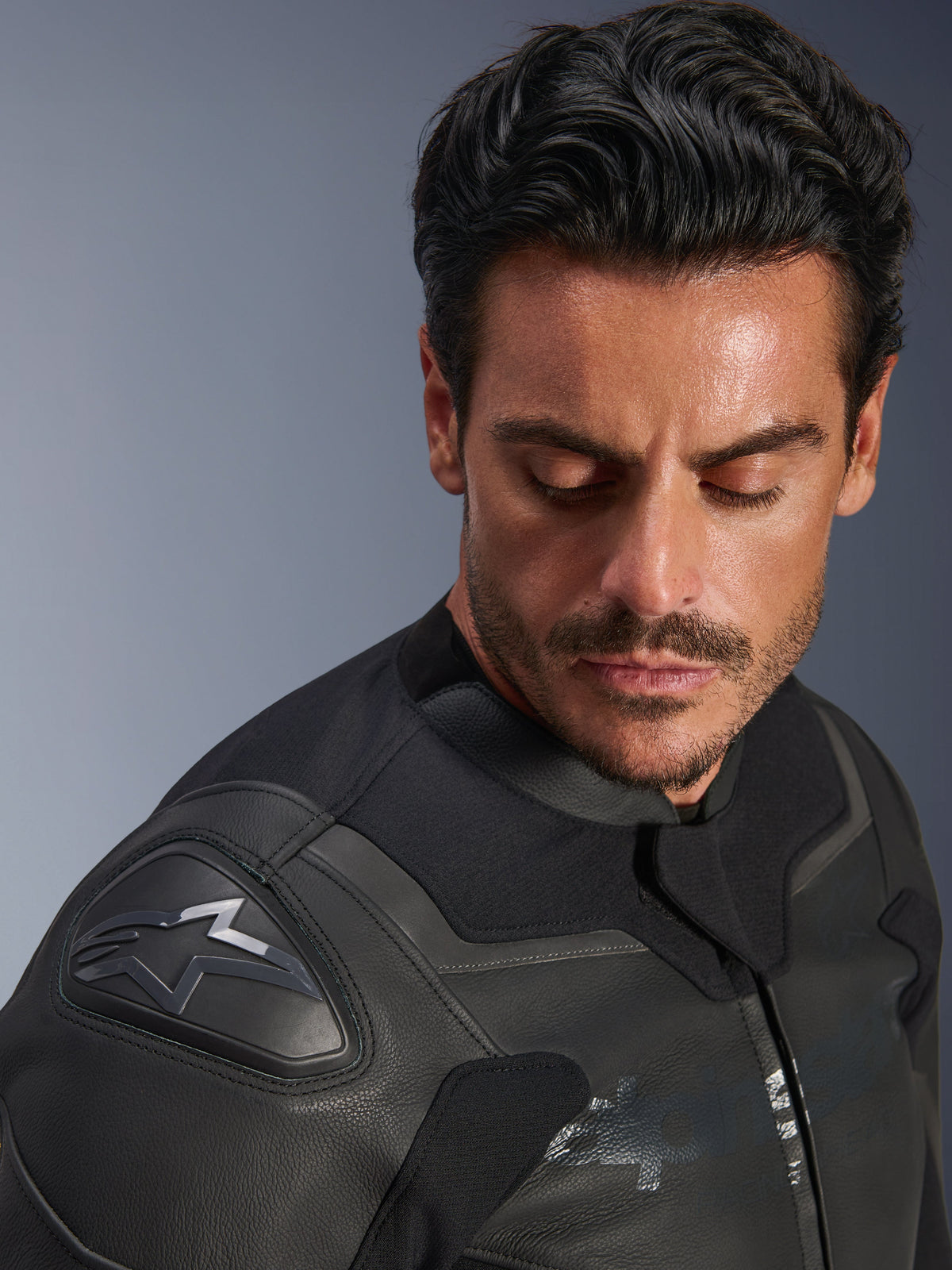 Giacca in pelle Alpinestars GP Force V2, nero, primo piano di un modello che indossa la giacca, focus sulla spalla con protezione GP Lite Evo DFS e logo Alpinestars, costruzione in pelle multi-pannello premium