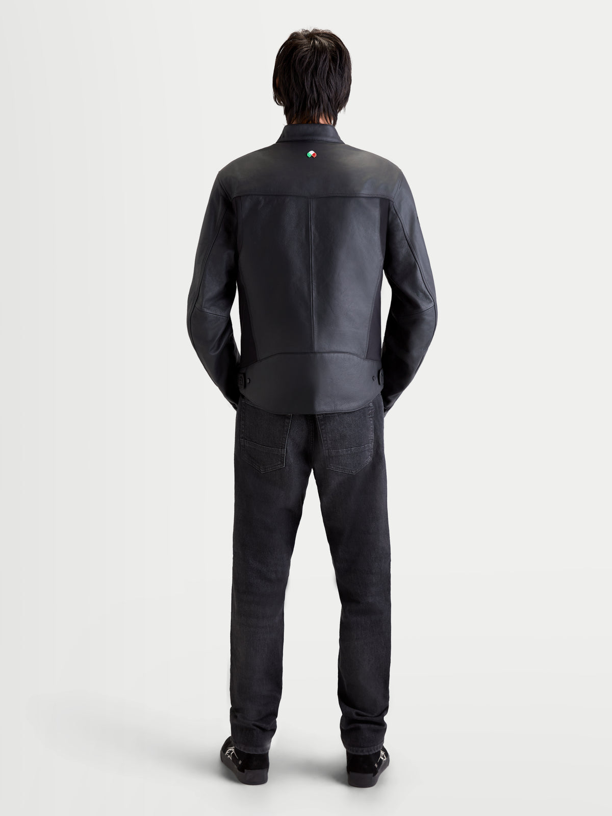 Alpinestars Maver X Giacca di pelle, giacca da moto urbana contemporanea da uomo, nero, vista posteriore su un modello che indossa jeans e scarpe scure abbinati, con struttura in pelle premium e dettaglio del colletto