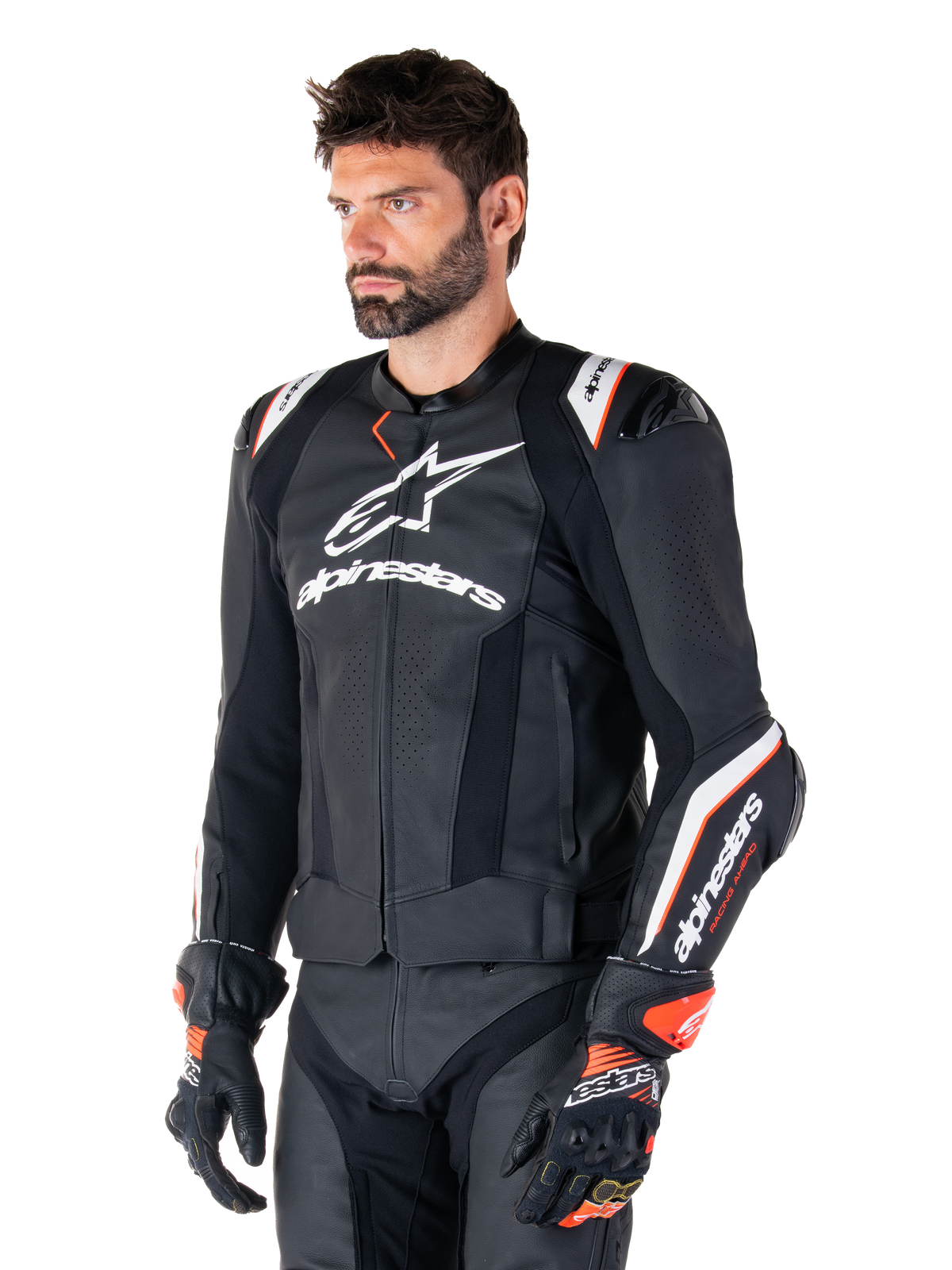 Modello uomo che indossa la giacca in pelle Alpinestars Missile V3 Ignition, nero con accenti bianchi e arancioni, caratterizzata da loghi bianchi evidenti, sezioni in pelle traforata e protezioni sulle spalle, abbinata a guanti da corsa per un look sportivo da gara.