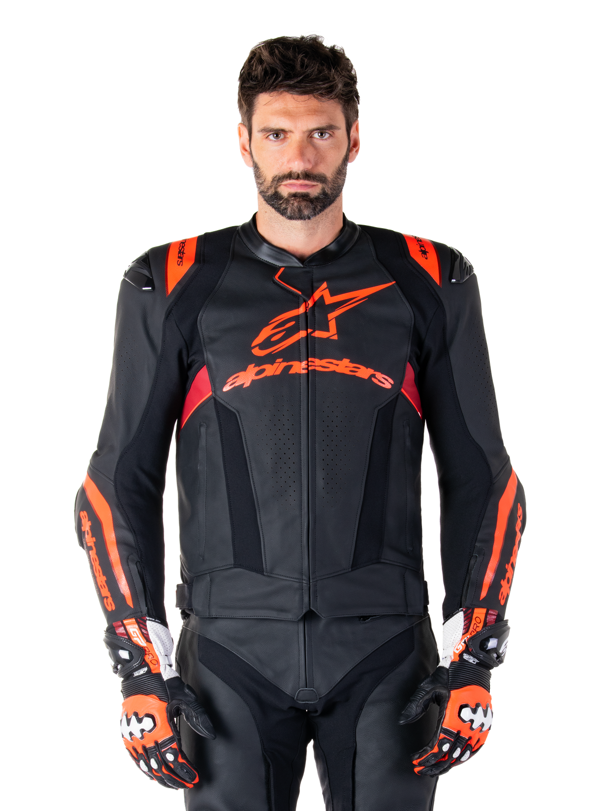 Giacca in pelle Alpinestars Missile V3 Ignition, giacca da moto racing, nero e rosso fluo, indossata con guanti da corsa e pantaloni in pelle coordinati, con ventilazione traforata e logo Alpinestars in evidenza, abbigliamento da corsa professionale