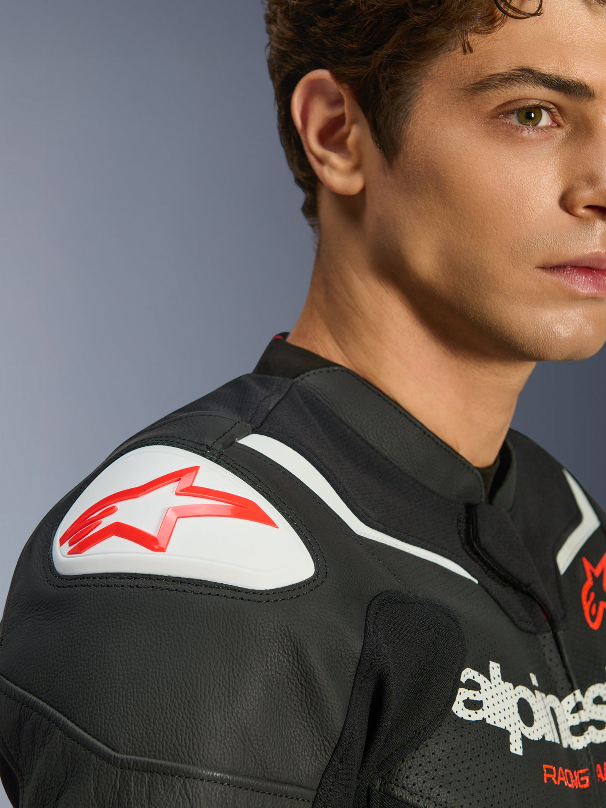 Alpinestars Giacca in pelle GP Force V2 Air, nero e bianco, primo piano del modello che indossa la giacca, con cursore sulla spalla GP Lite Evo DFS bianco con logo rosso e dettagli in pelle traforata.