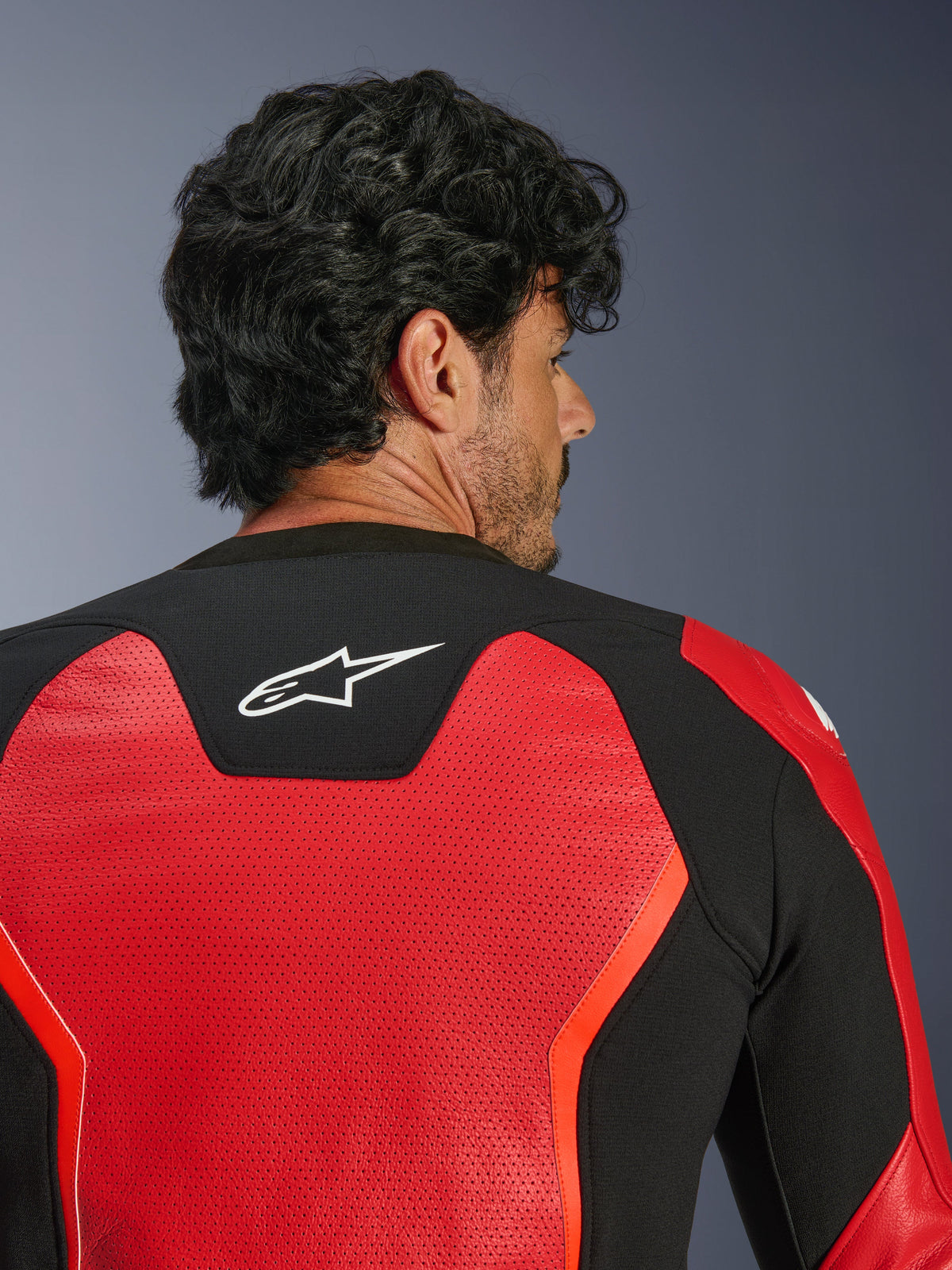 Alpinestars GP Force V2 Air Leather Jacket, rossa e nera, vista ravvicinata posteriore con pelle ampiamente traforata per il flusso d'aria, pannello elasticizzato nero con logo Astars bianco, giacca da moto con vestibilità sportiva
