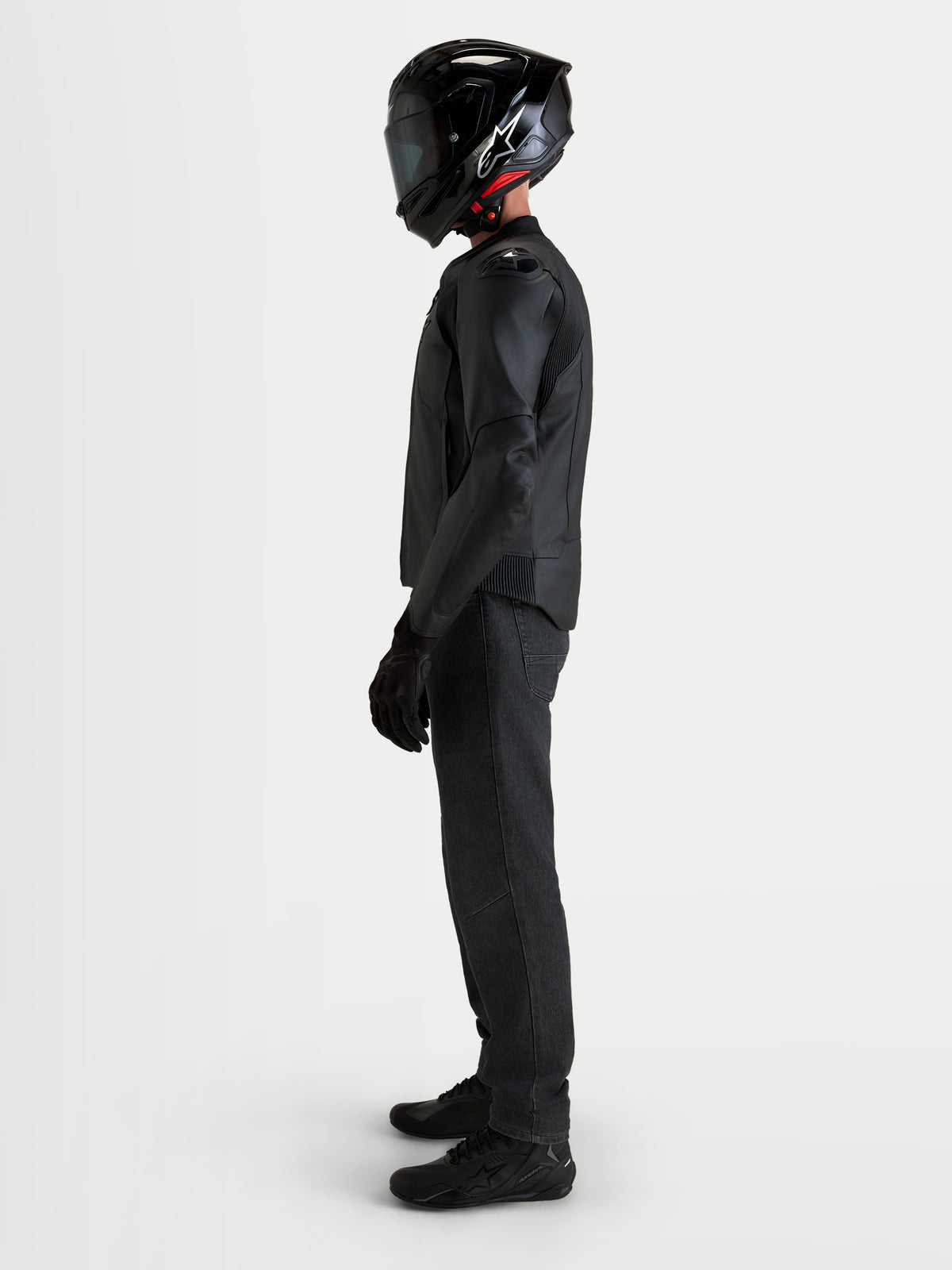 Alpinestars Caliber V2 Giacca di pelle, giacca da moto in pelle nera da uomo con protezioni DFS sulle spalle e protezione certificata CE AA, indossata da un pilota in vista di profilo